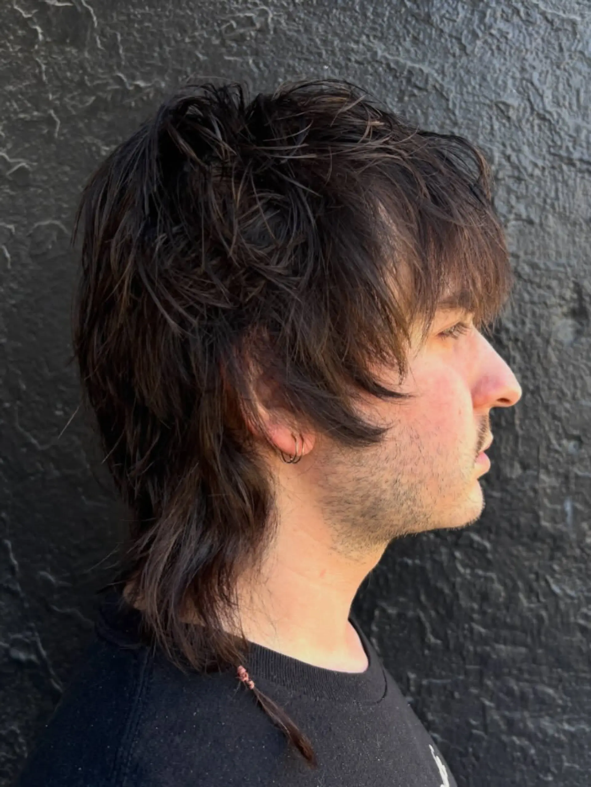 A textured mod shag featuring heavy forward-swept bangs, piecey layered crown volume, and length extended down the nape. 1