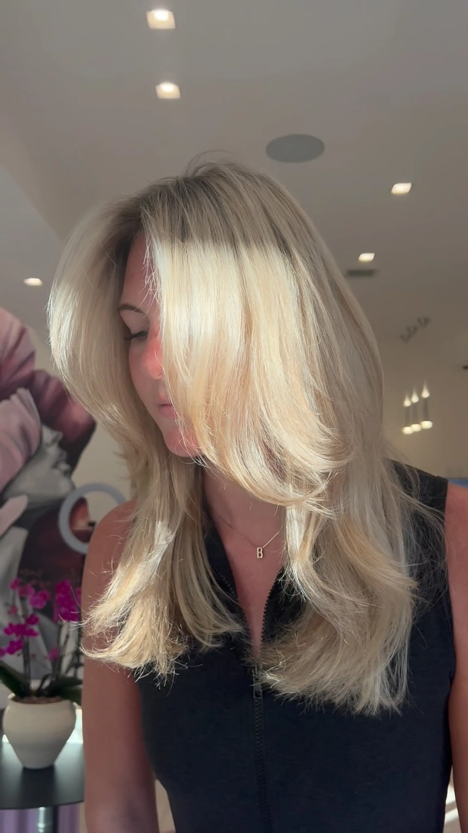Bright blonde long hair styled in a bouncy, voluminous blowout with sweeping face-framing layers. 1