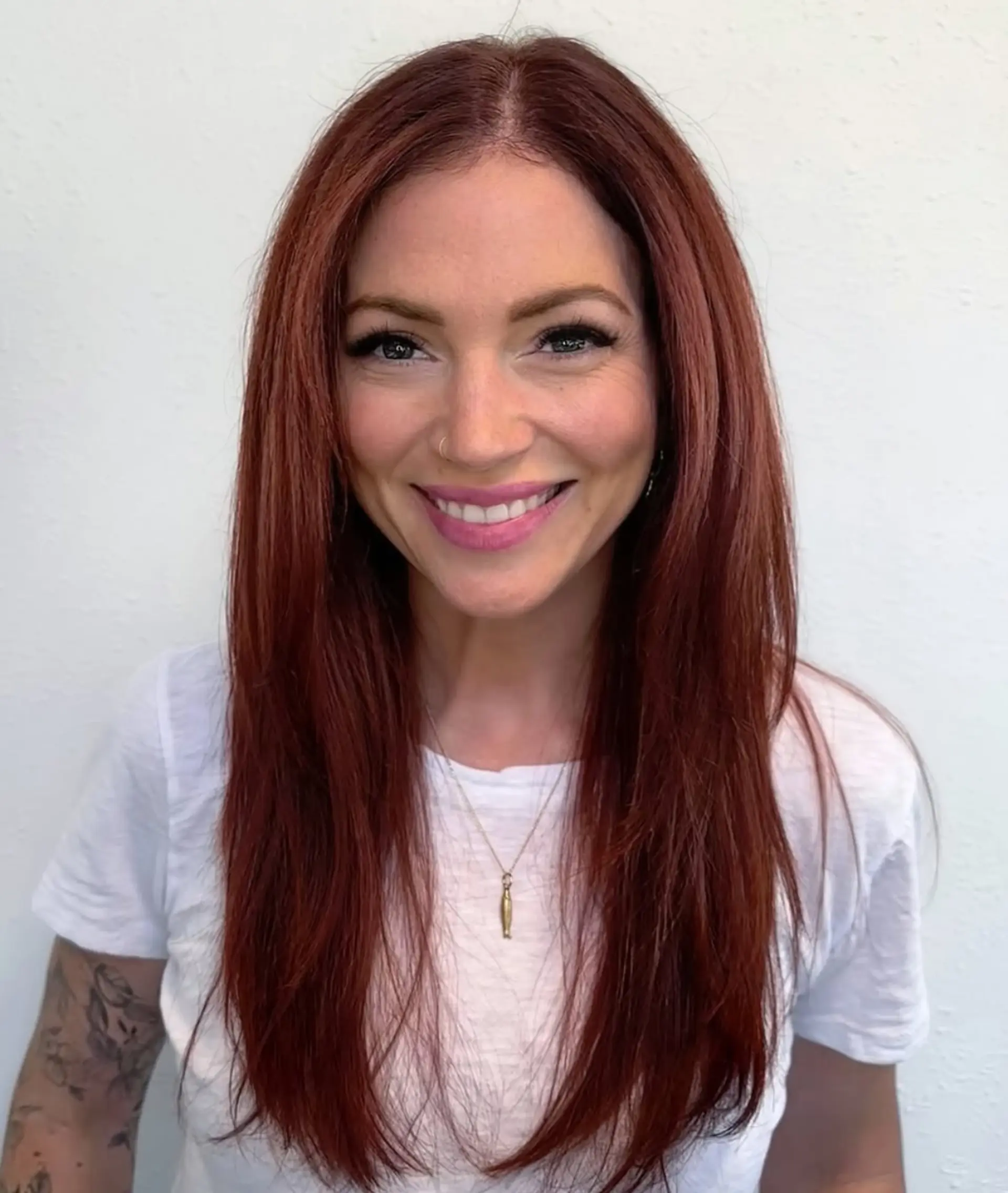 Long, smooth straight hair dyed a vibrant auburn red with soft face-framing layers and a center part. 1