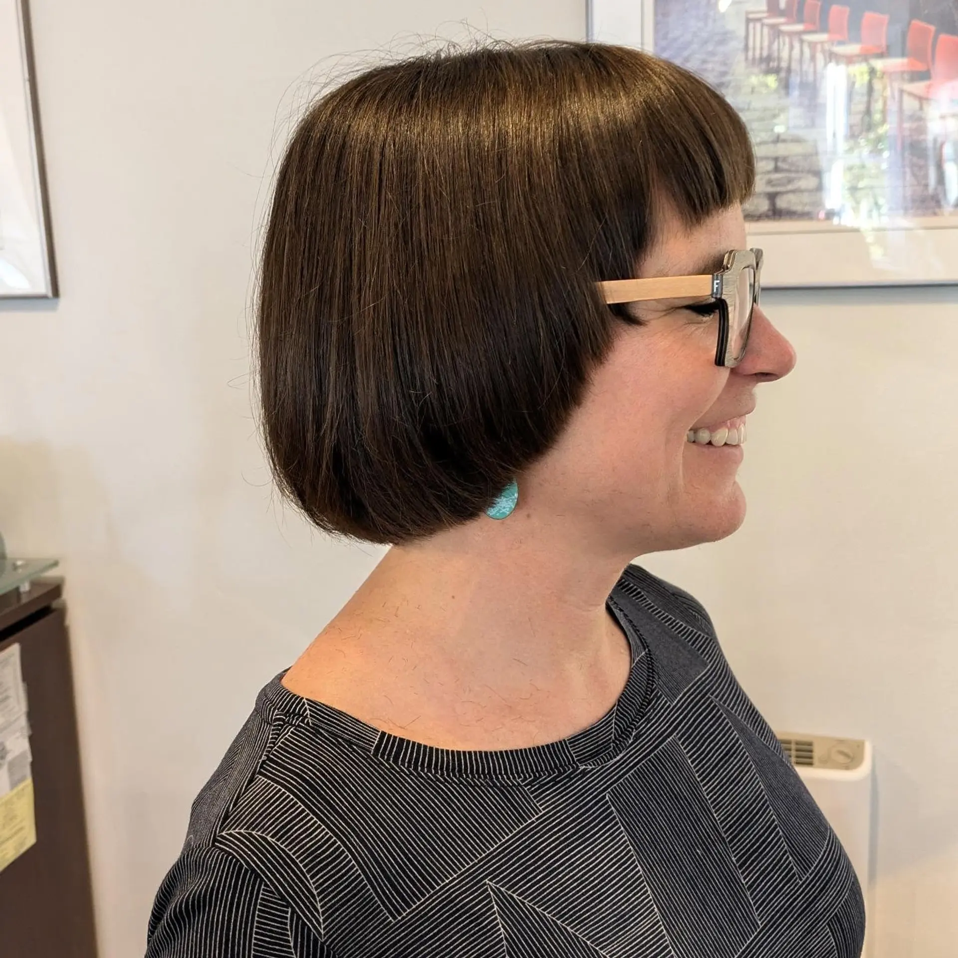 A sleek, rounded chin-length brunette bob with blunt micro bangs hugging the face. 1