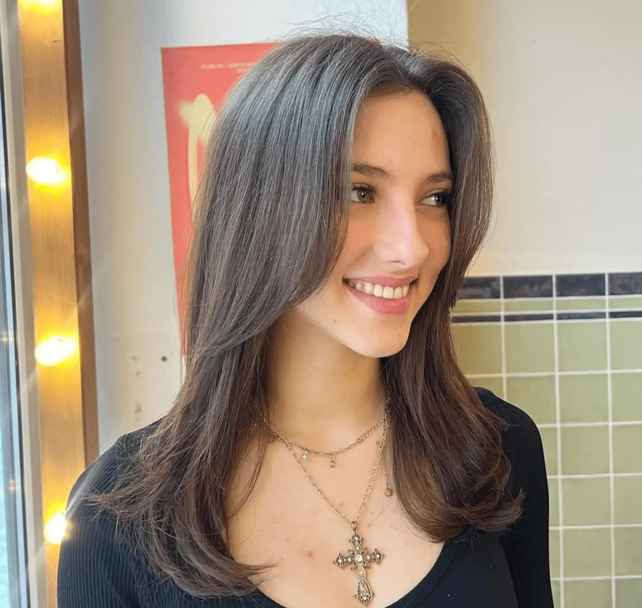 Beautifully crafted medium-length hairstyle with straight, dark brown hair styled into classic, elegant layers with a middle part, showcasing soft volume and natural shine.