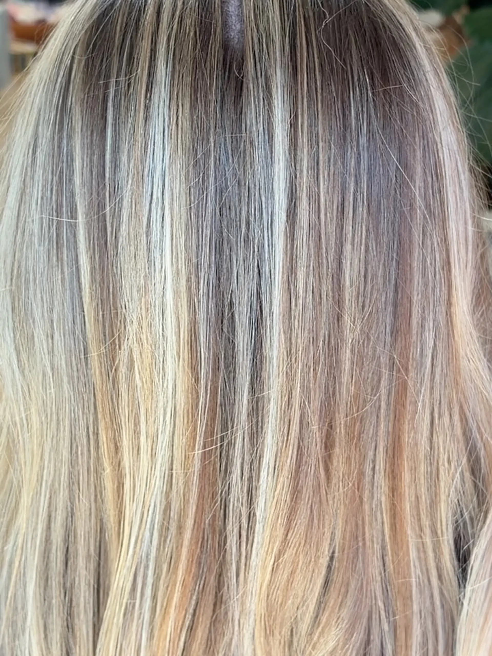 Straight hair featuring multi-dimensional full blonde foil highlights blended seamlessly into a darker base. 1
