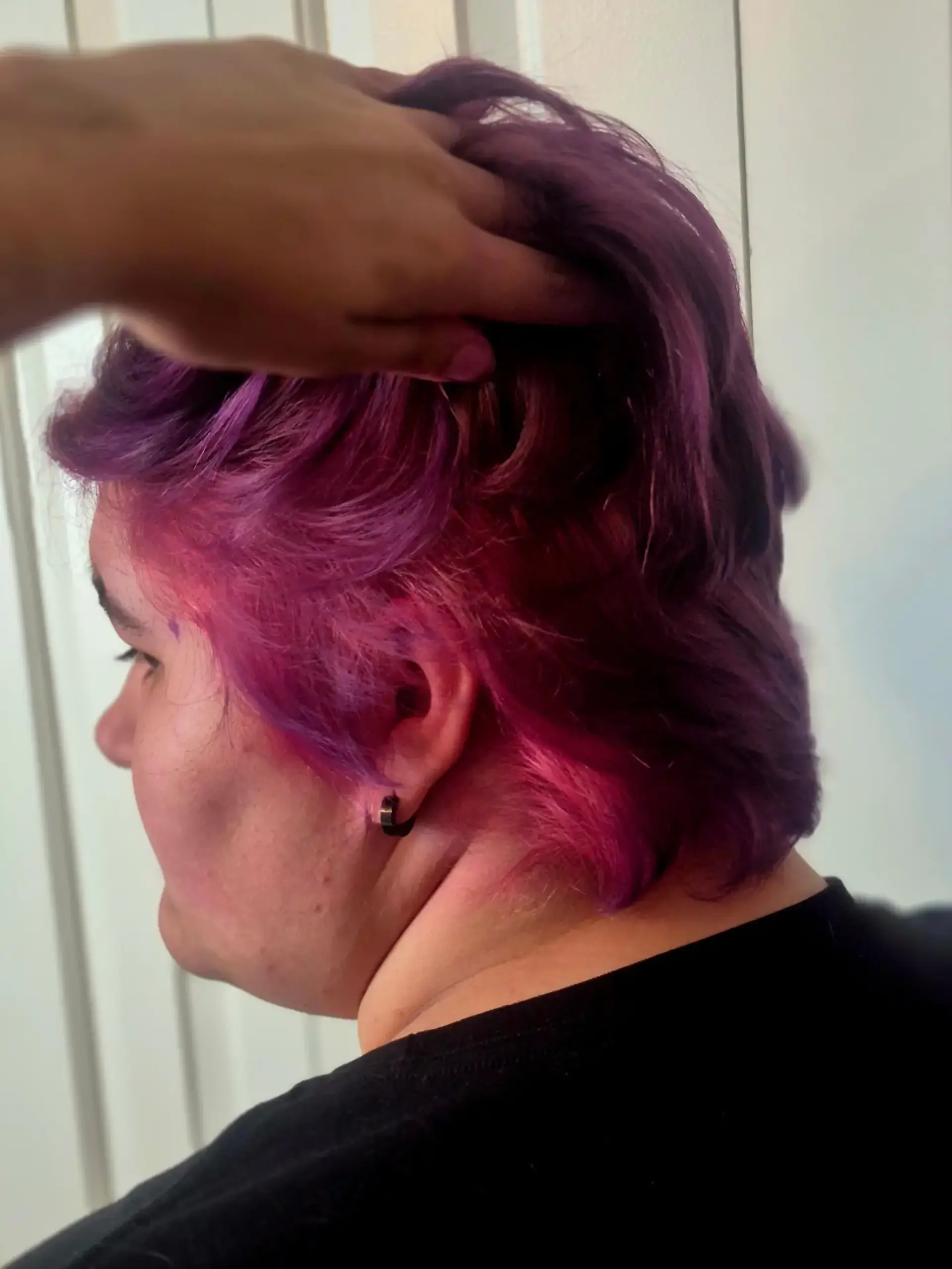 Short textured cut featuring deep purple hair with vibrant pink ghost roots revealed underneath. 1