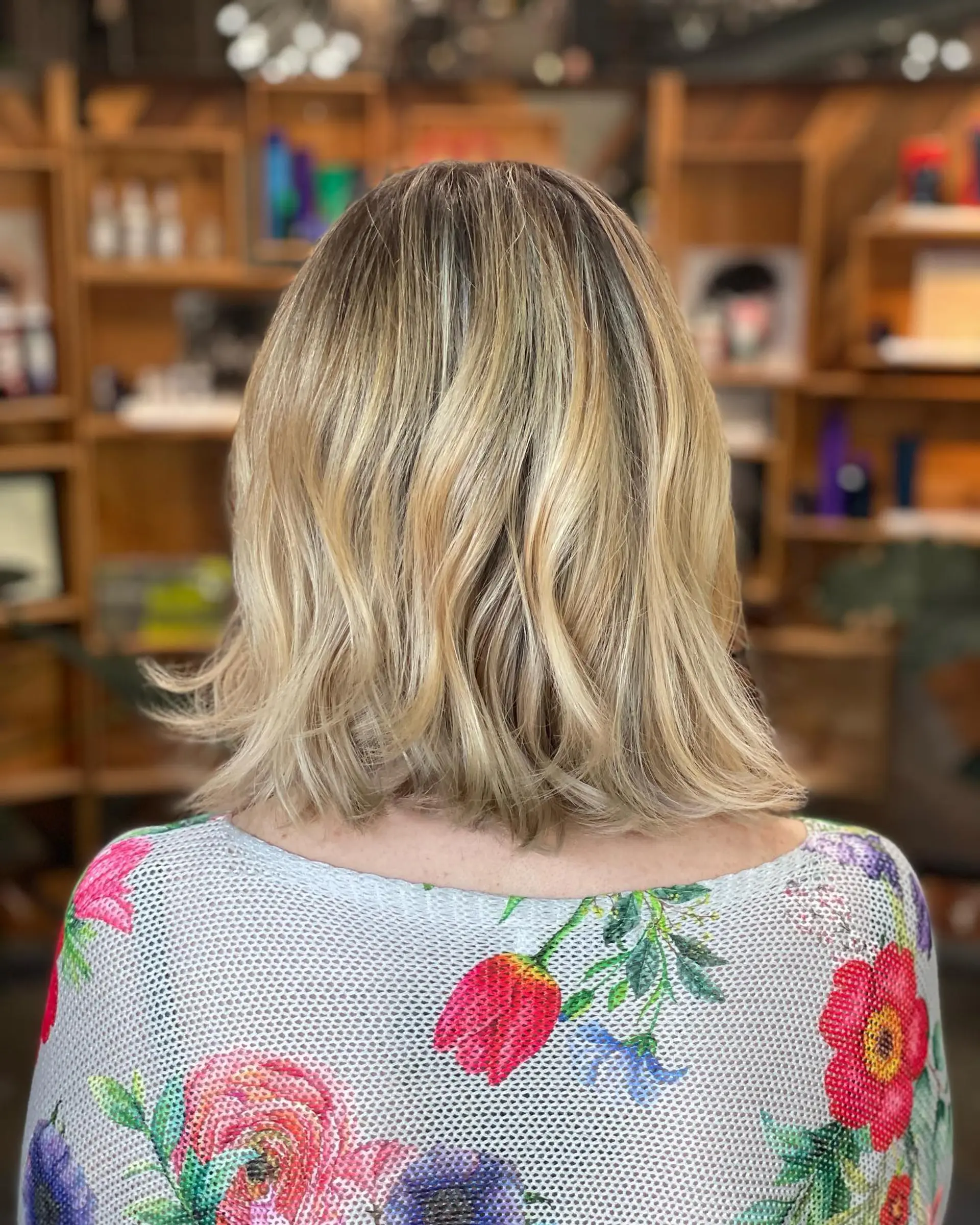 A shoulder-length textured lob with dimensional blonde highlights and soft, subtle waves. 1