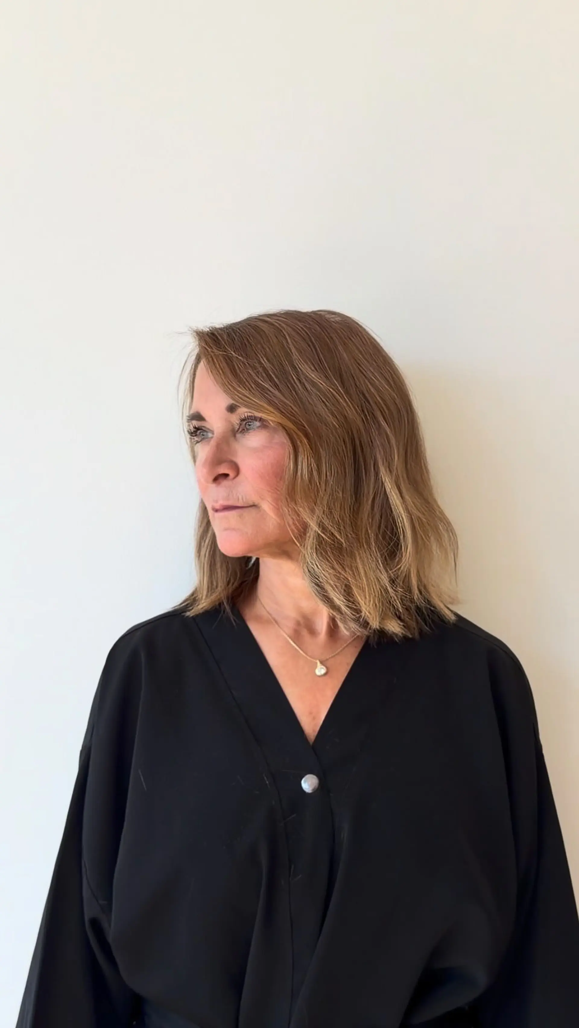 A textured, shoulder-skimming lob styled with subtle, lived-in waves and warm, dimensional highlights. 1