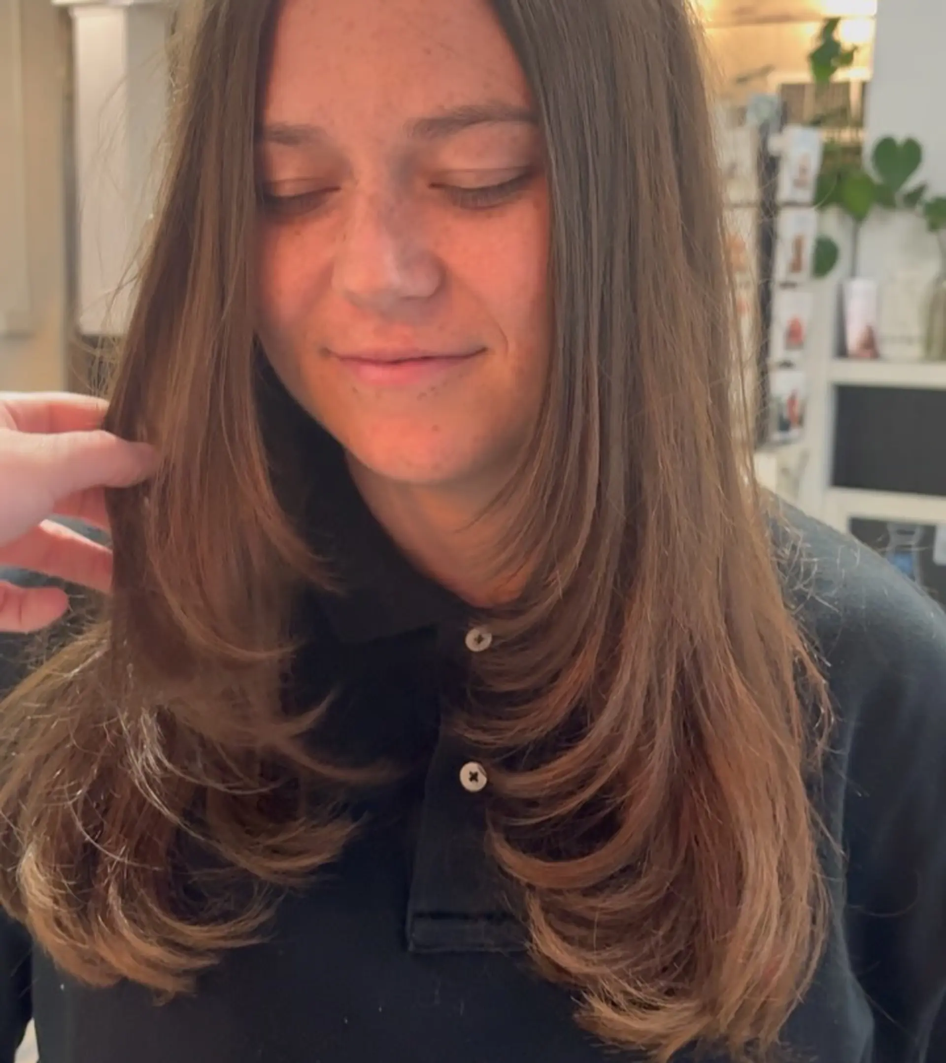 Long brunette hair featuring tiered, face-framing layers cut seamlessly into the length and styled with soft, inward-curled ends. 1