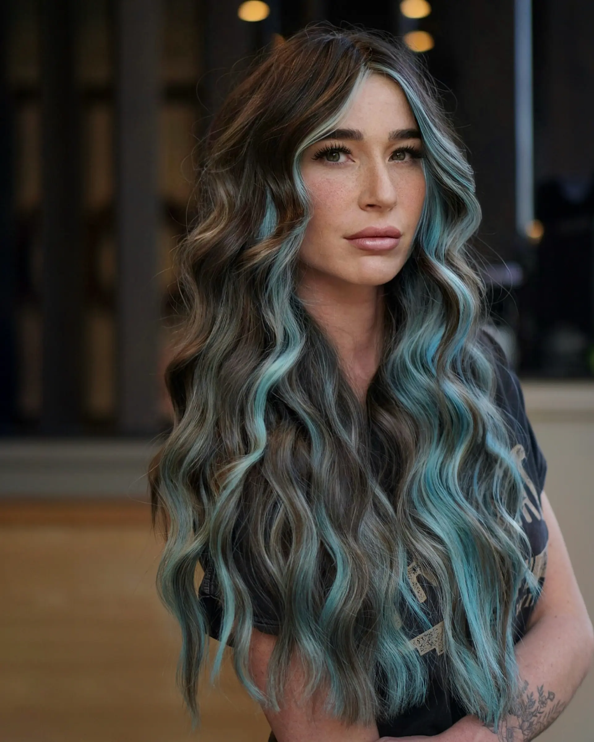Long, cascading brunette waves featuring a bold, contrasting baby blue face-framing money piece. 1