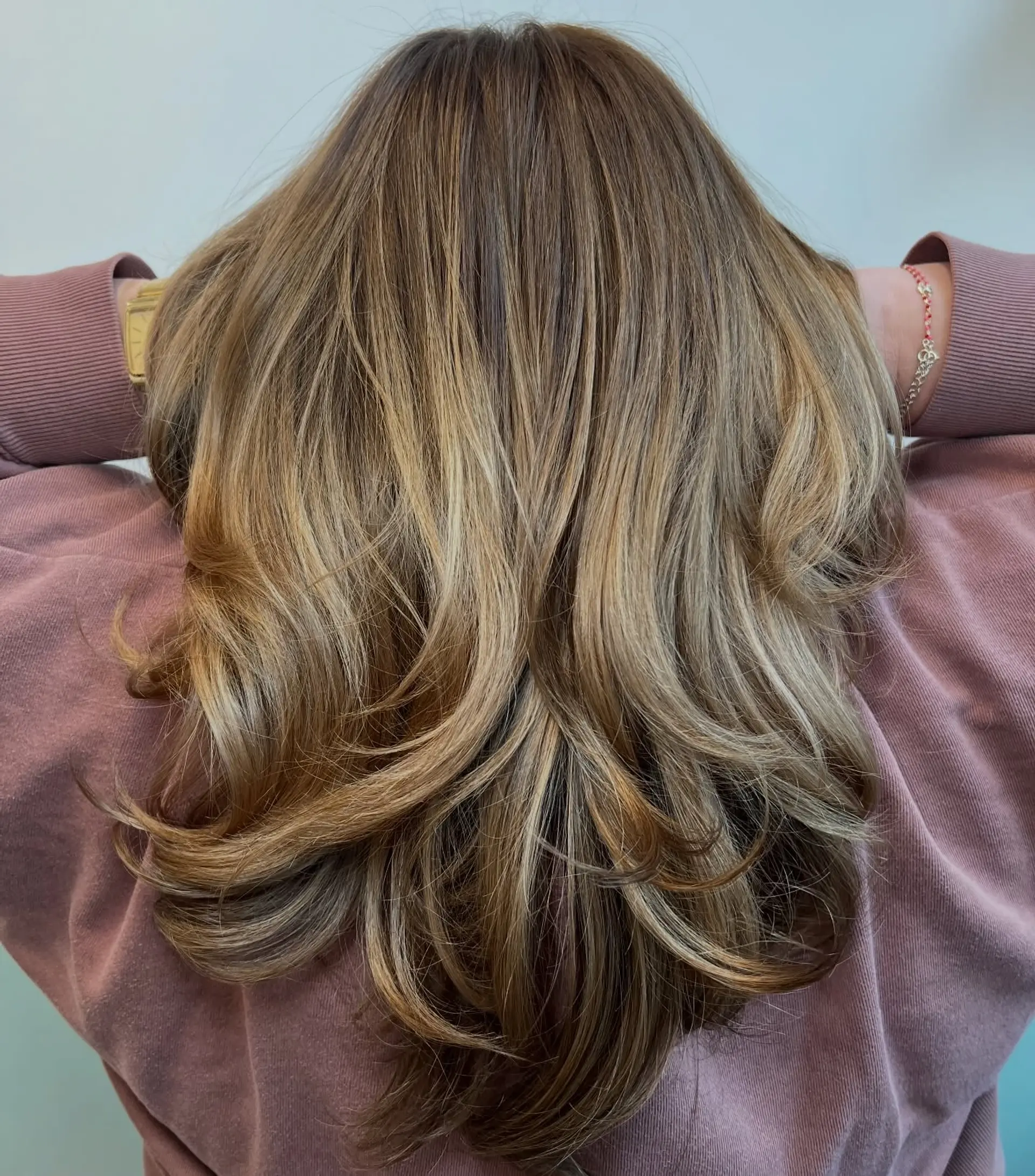 Long layered butterfly haircut with flipped ends and warm blonde dimensional highlights. 1