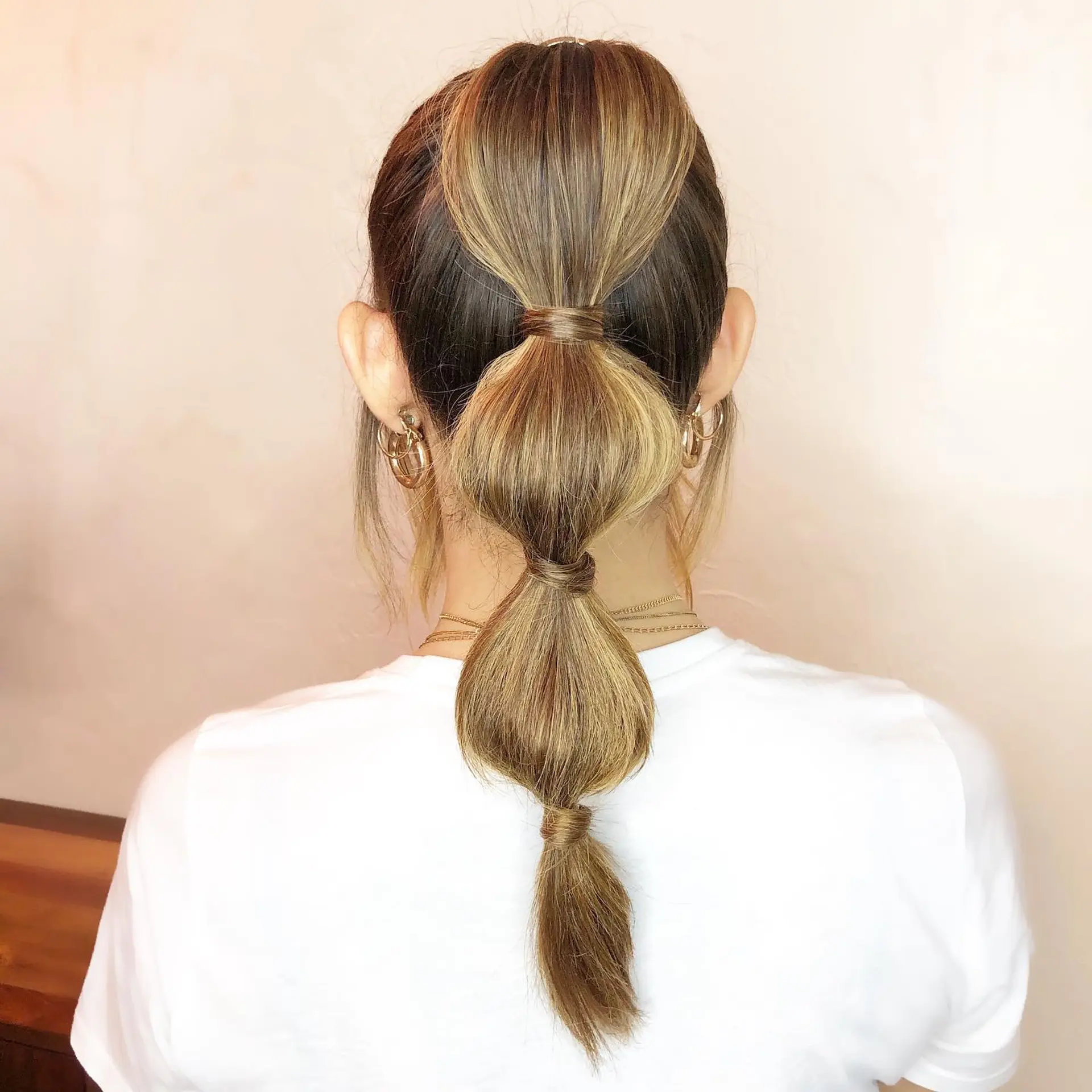 A sleek segmented bubble ponytail with hair-wrapped elastics defining rounded sections. 1