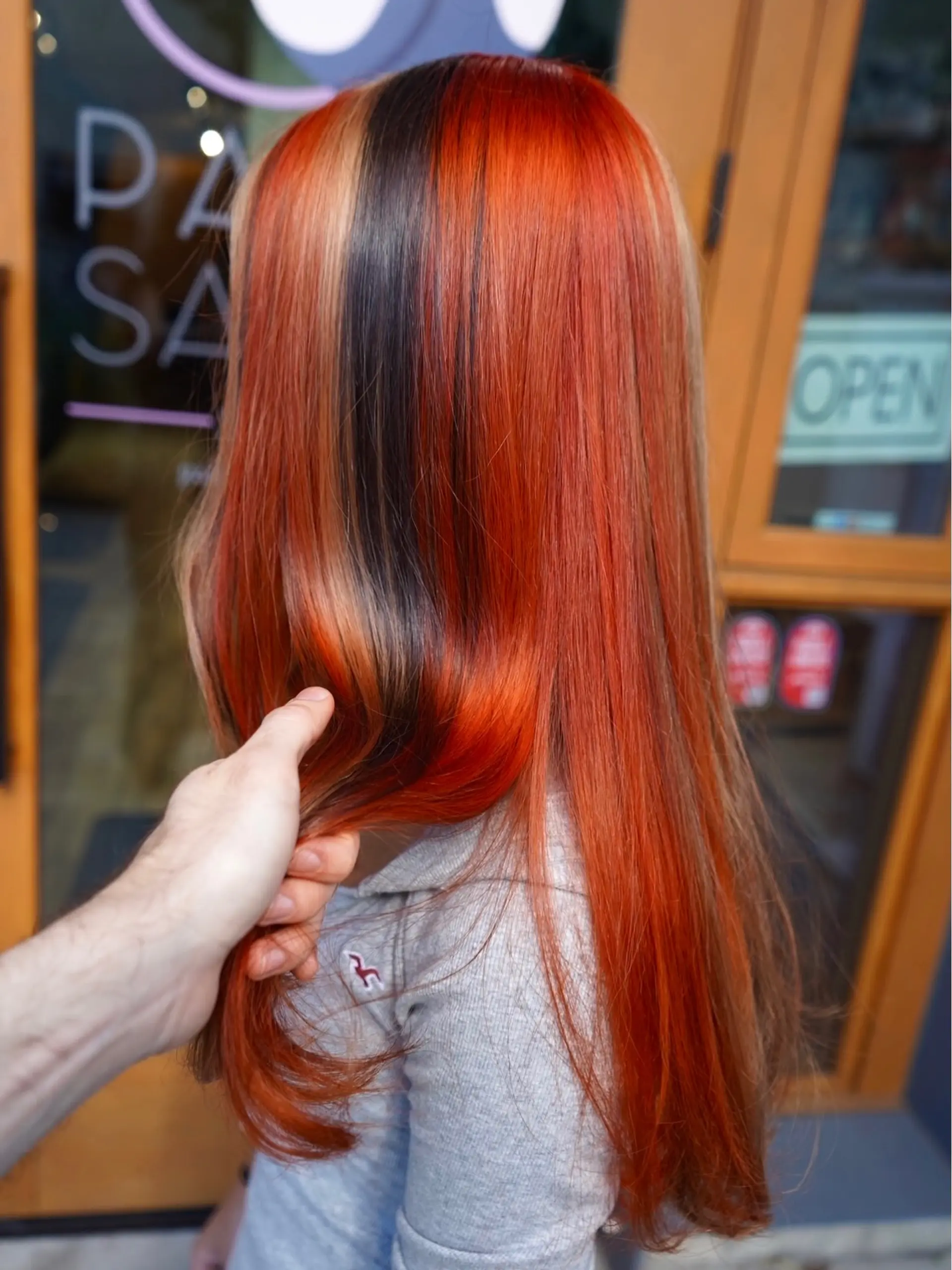 Long straight hair featuring a vibrant calico color-blocked pattern with red, black, and blonde panels. 1