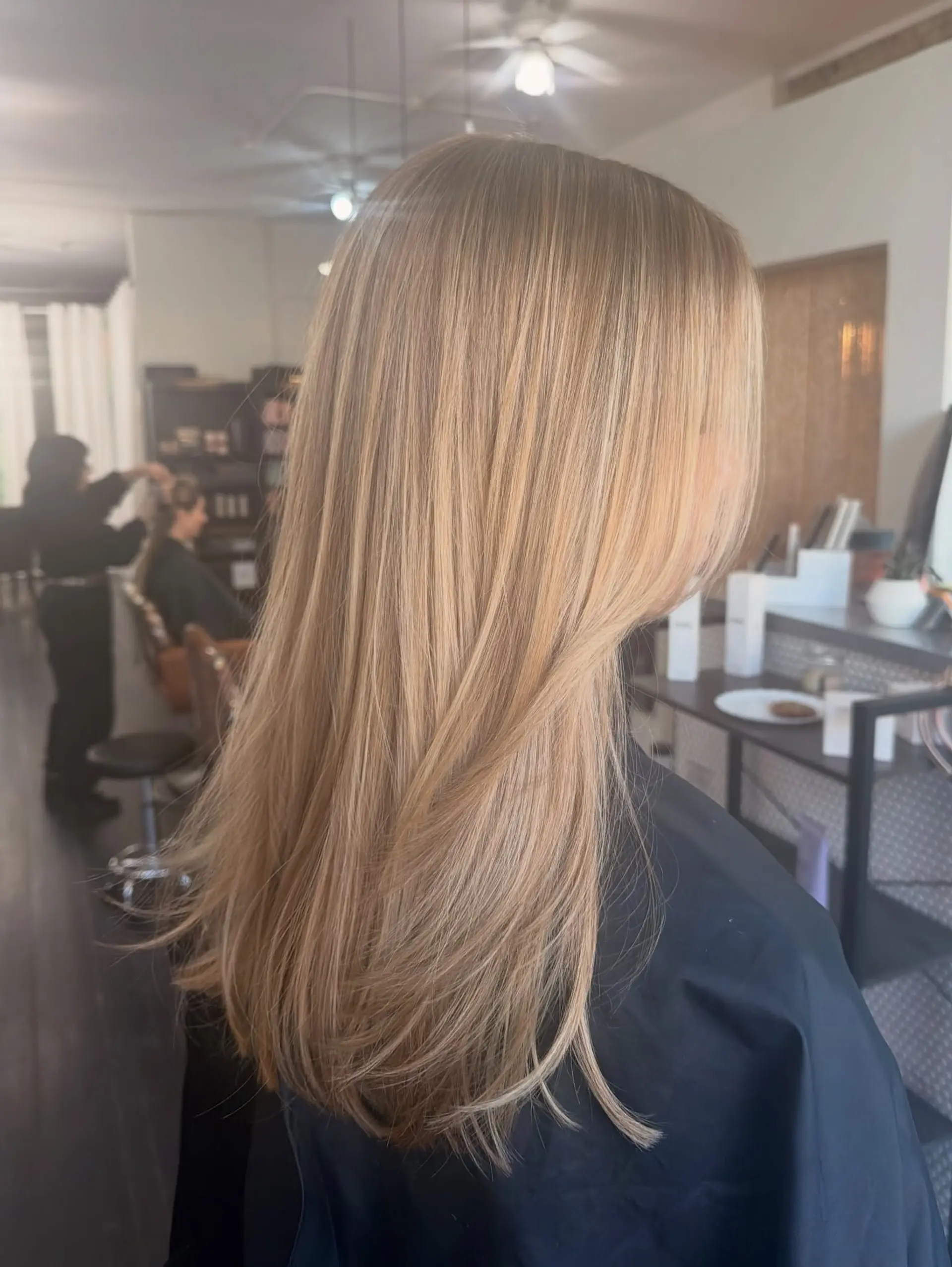Long, smooth blonde hair styled straight with soft curled-under ends, showcasing dimensional highlights and lowlights. 1