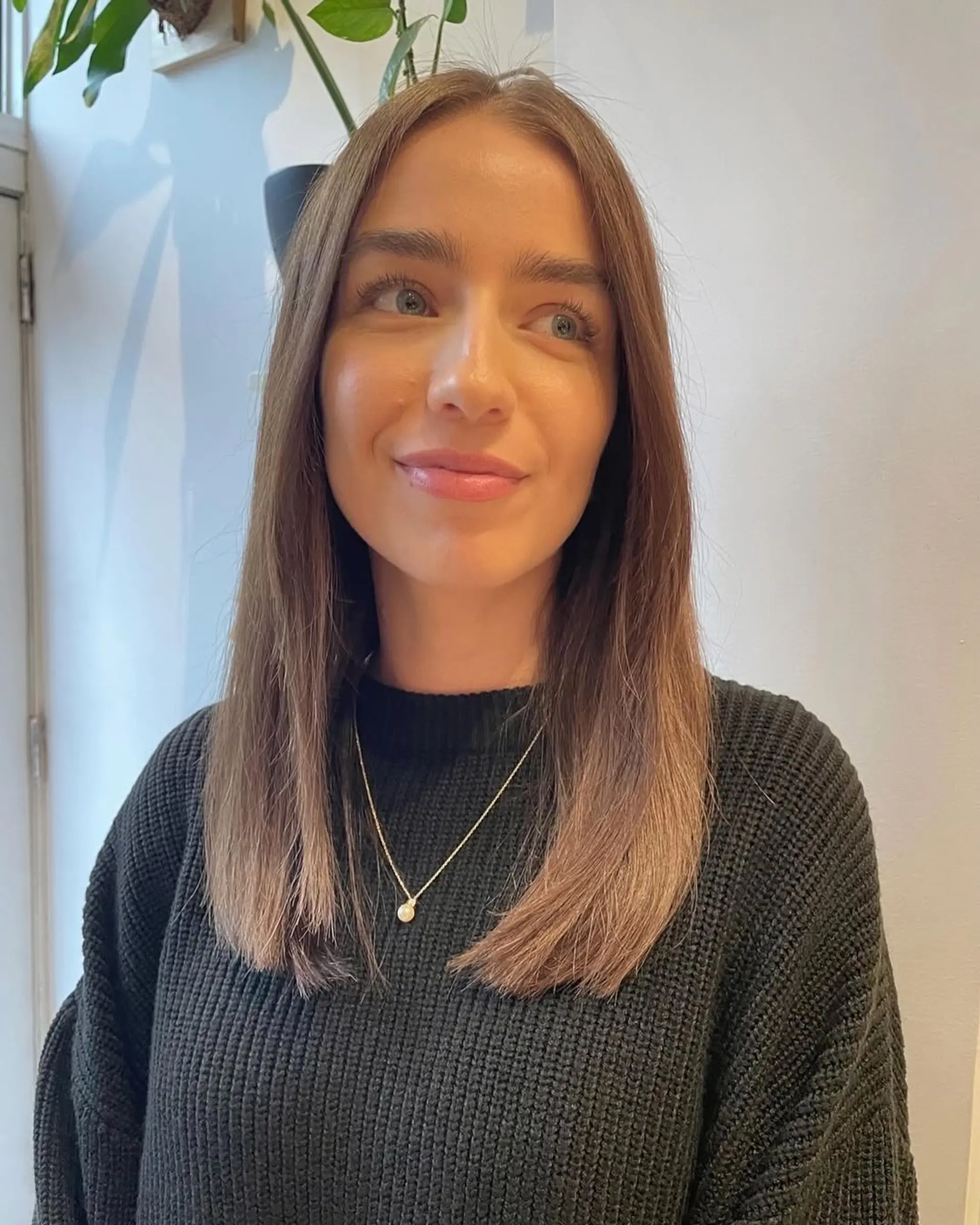 A stylish straight lob with subtle layers and a center part, featuring a brown to blonde ombre effect. 1