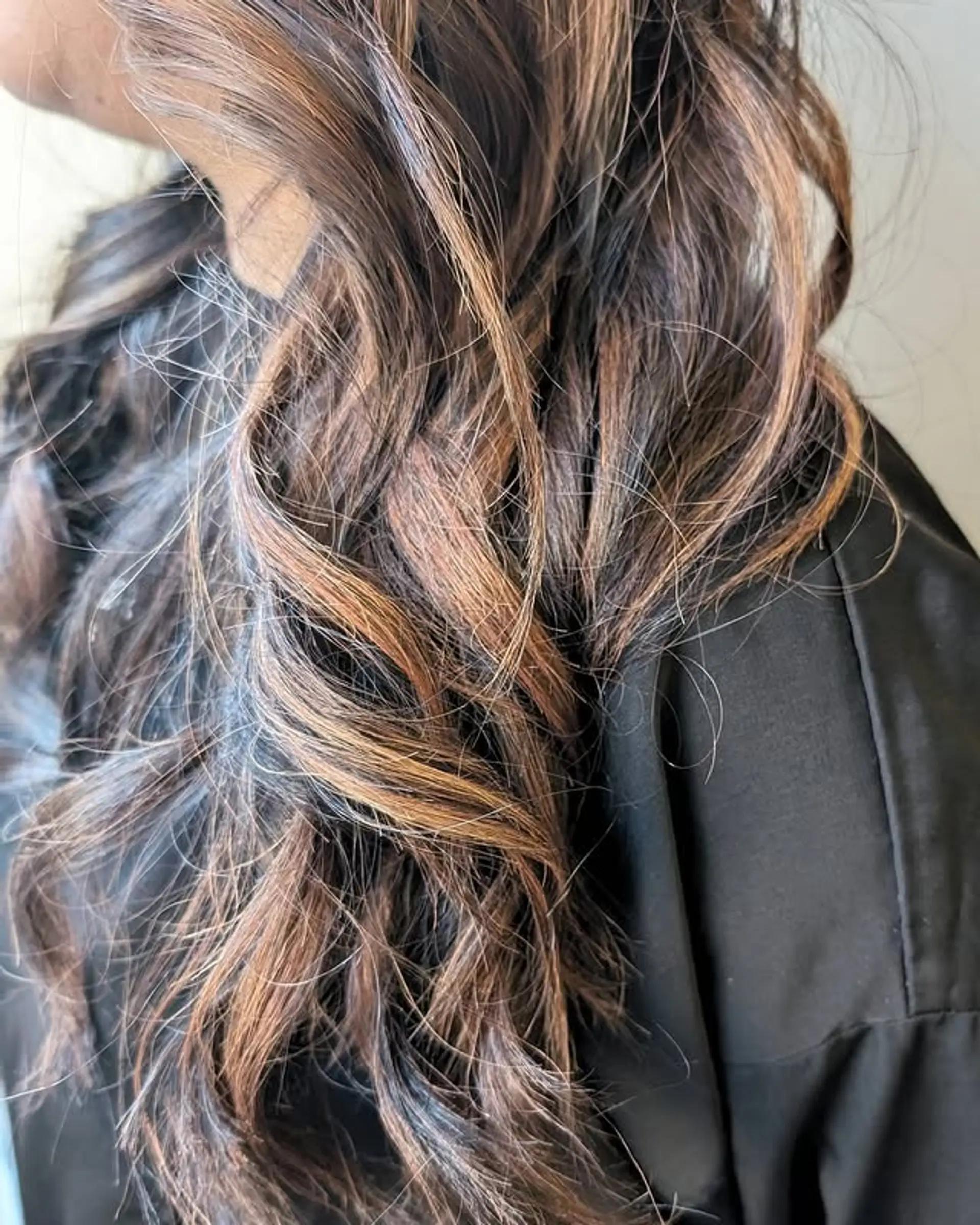 A medium-length wavy hairstyle with a bronzed balayage. 1