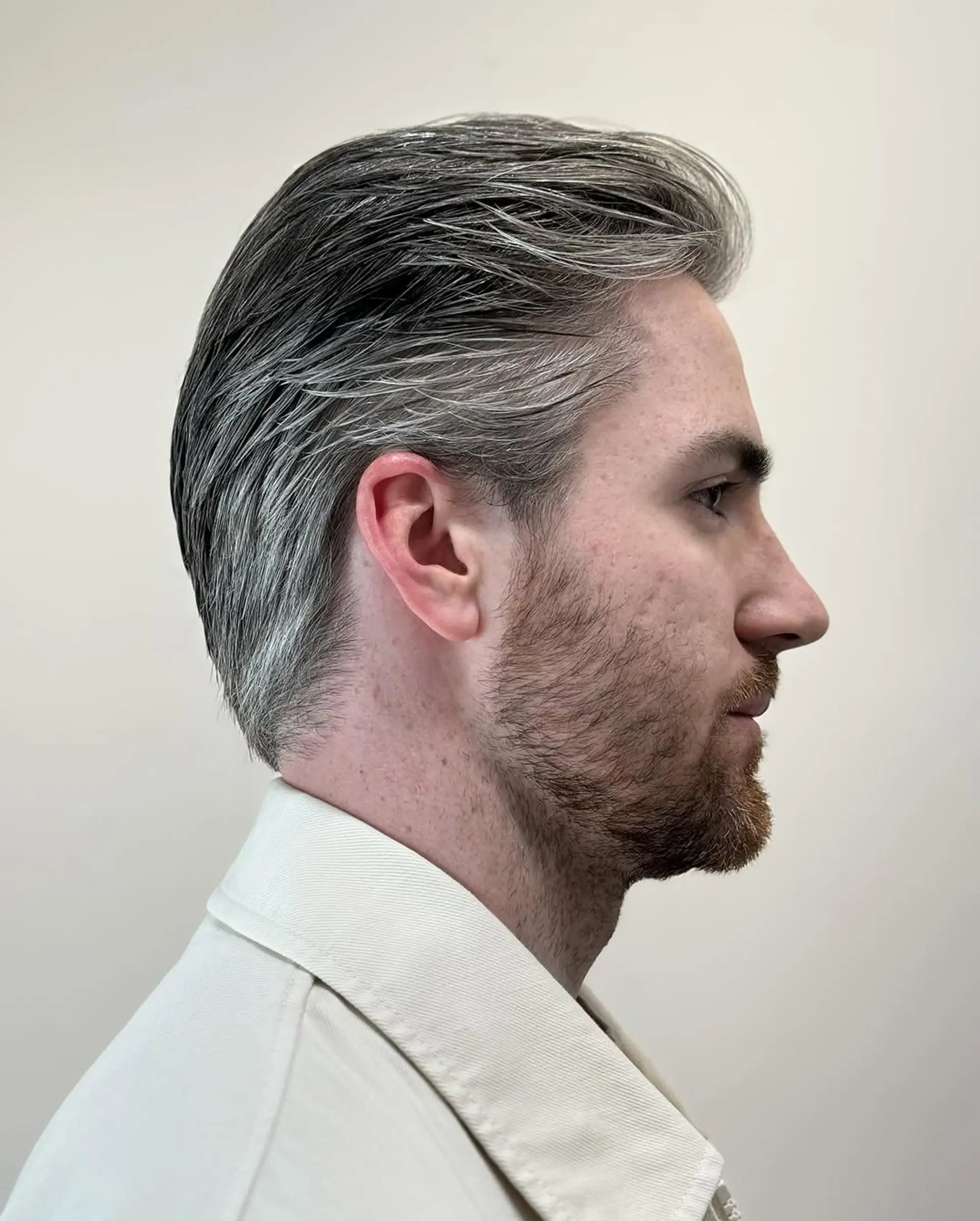 Short wavy hairstyle with a side part, featuring textured waves in silver and gray, providing a natural flow and sleek finish. 3