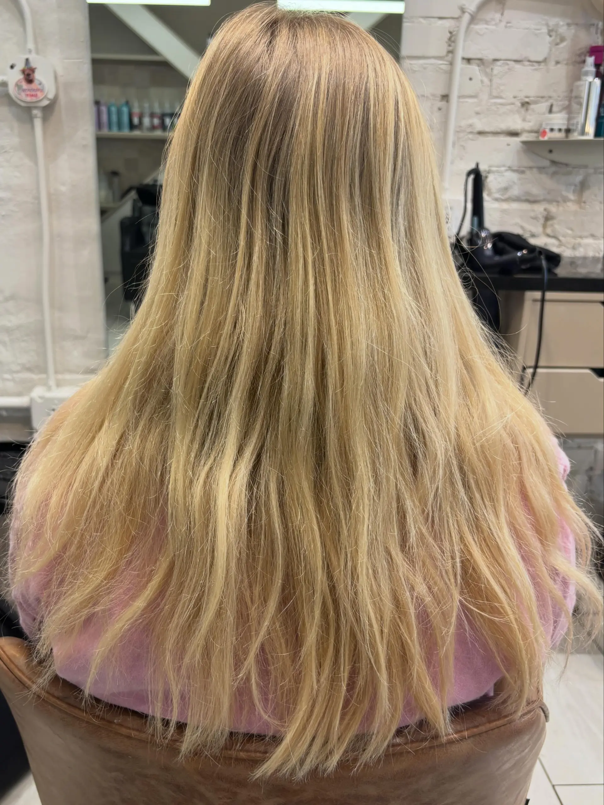 Long straight blonde hair featuring soft dimensional highlights draped smoothly down the back. 1