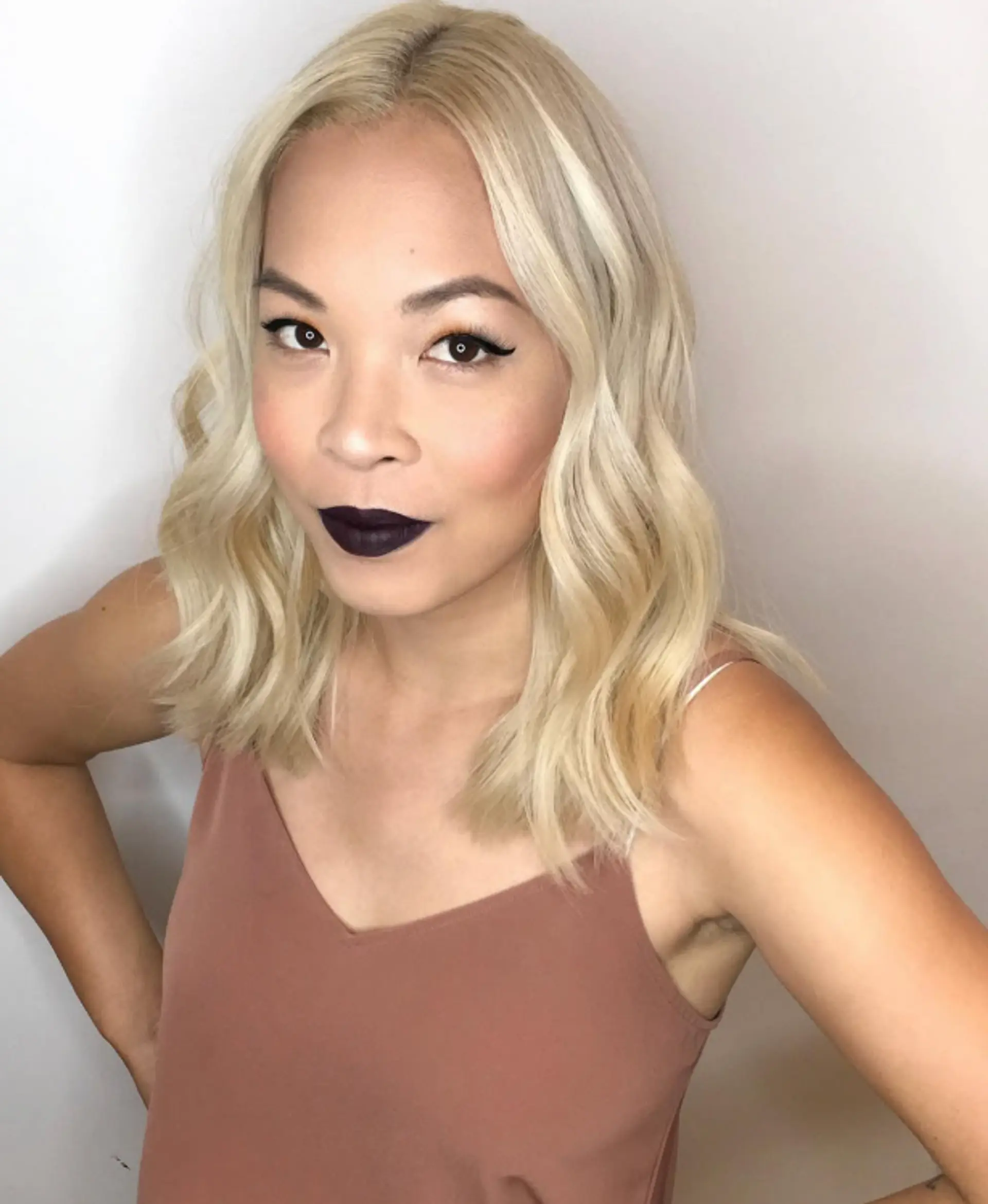 Medium-length wavy hair styled in loose beach waves with a trendy icy blonde color. 1