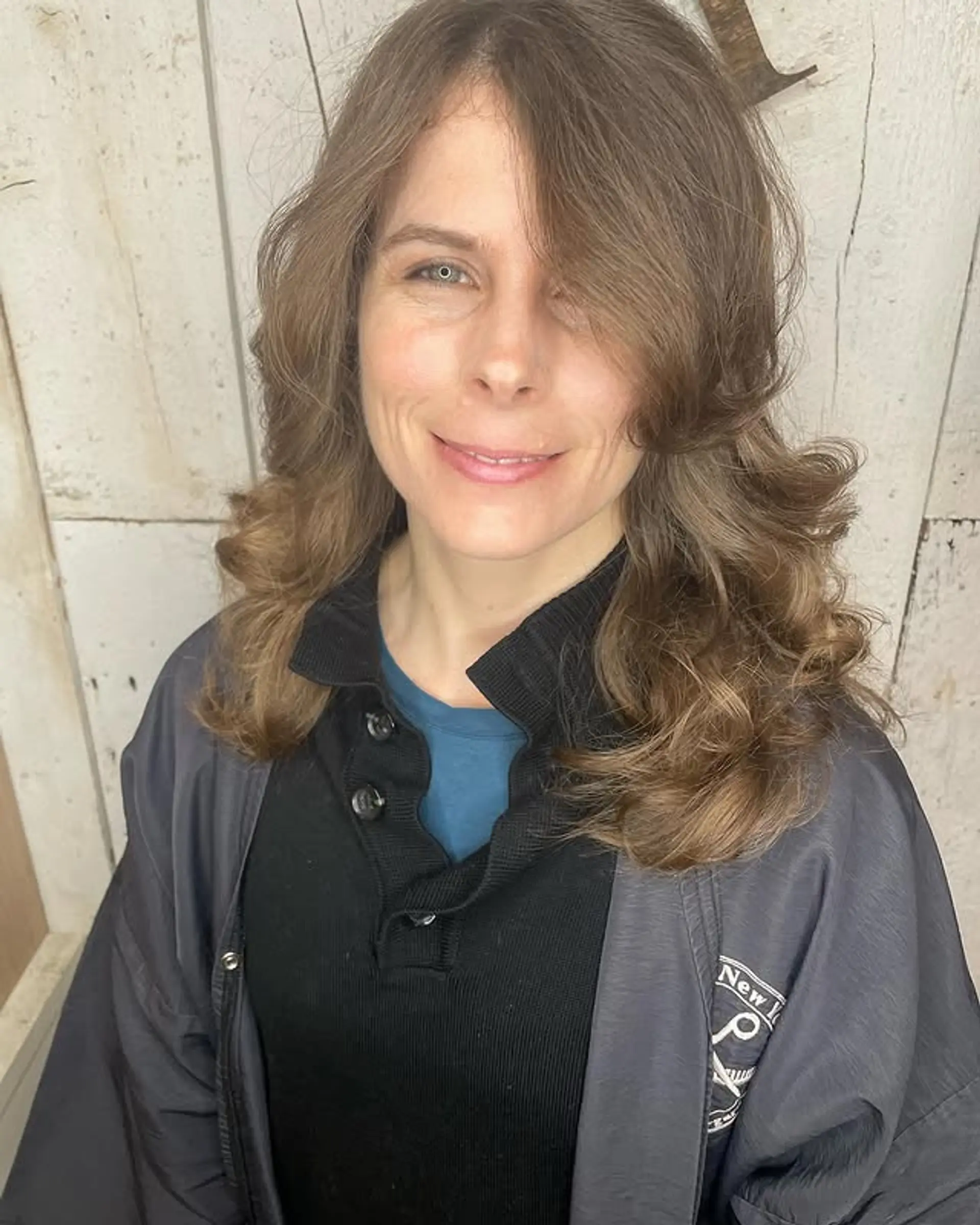 A layered medium-length cut with soft waves and curtain bangs, styled into a bouncy blowout. 1