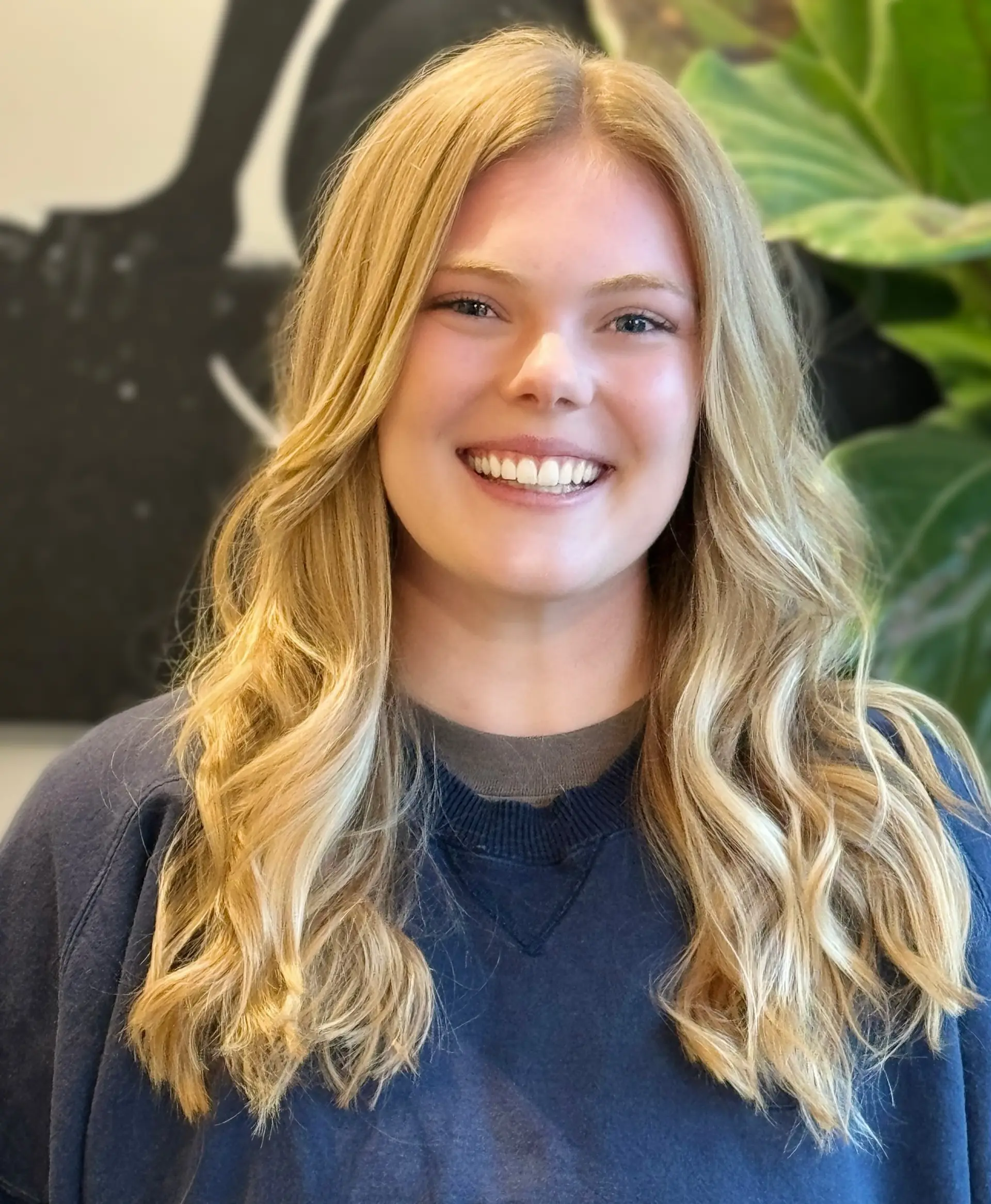 Long sun-kissed golden blonde hair styled in soft, loose waves with a natural center part. 1