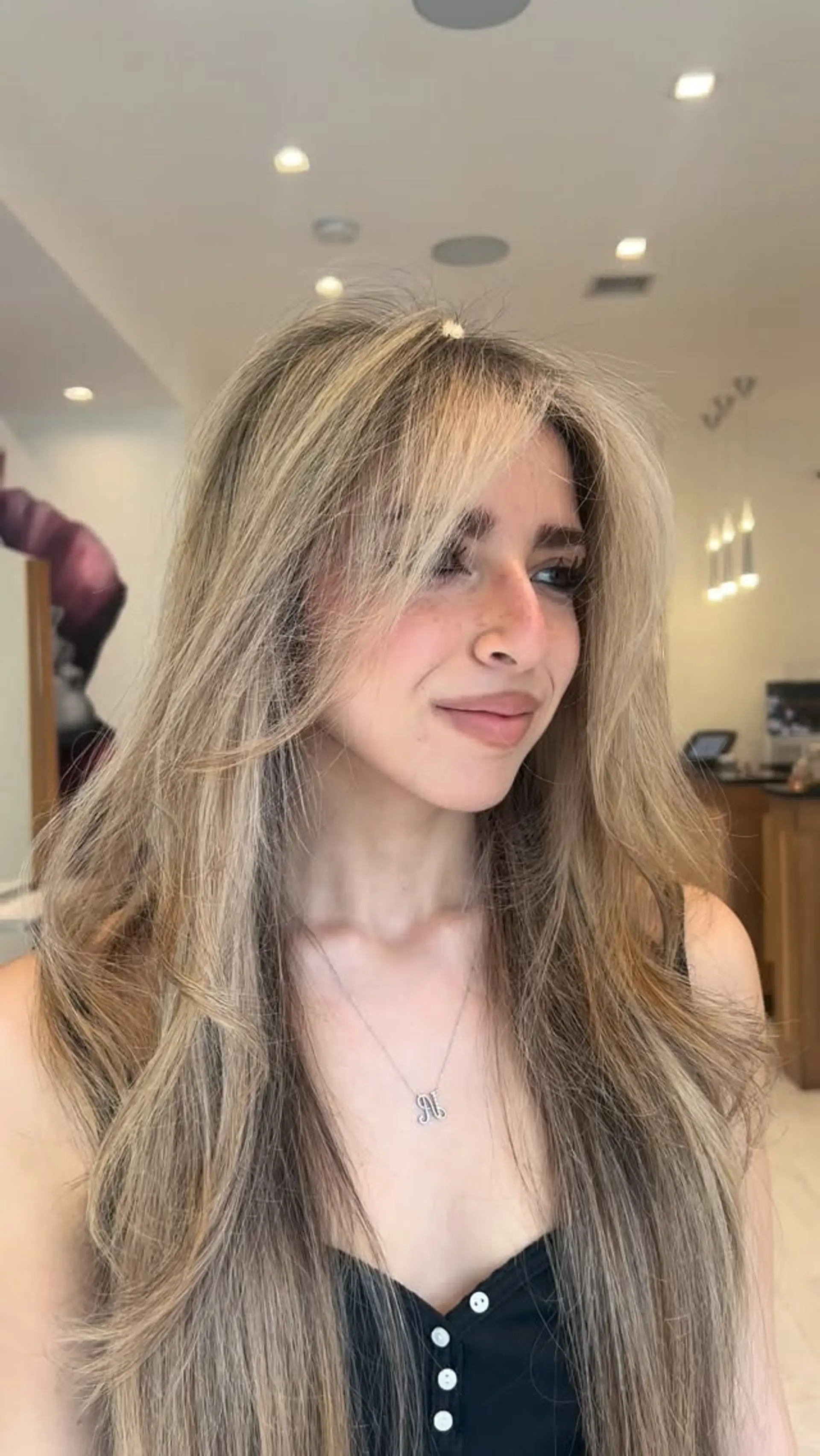 Long beige blonde balayage styled with soft, voluminous layers and face-framing curtain bangs. 1