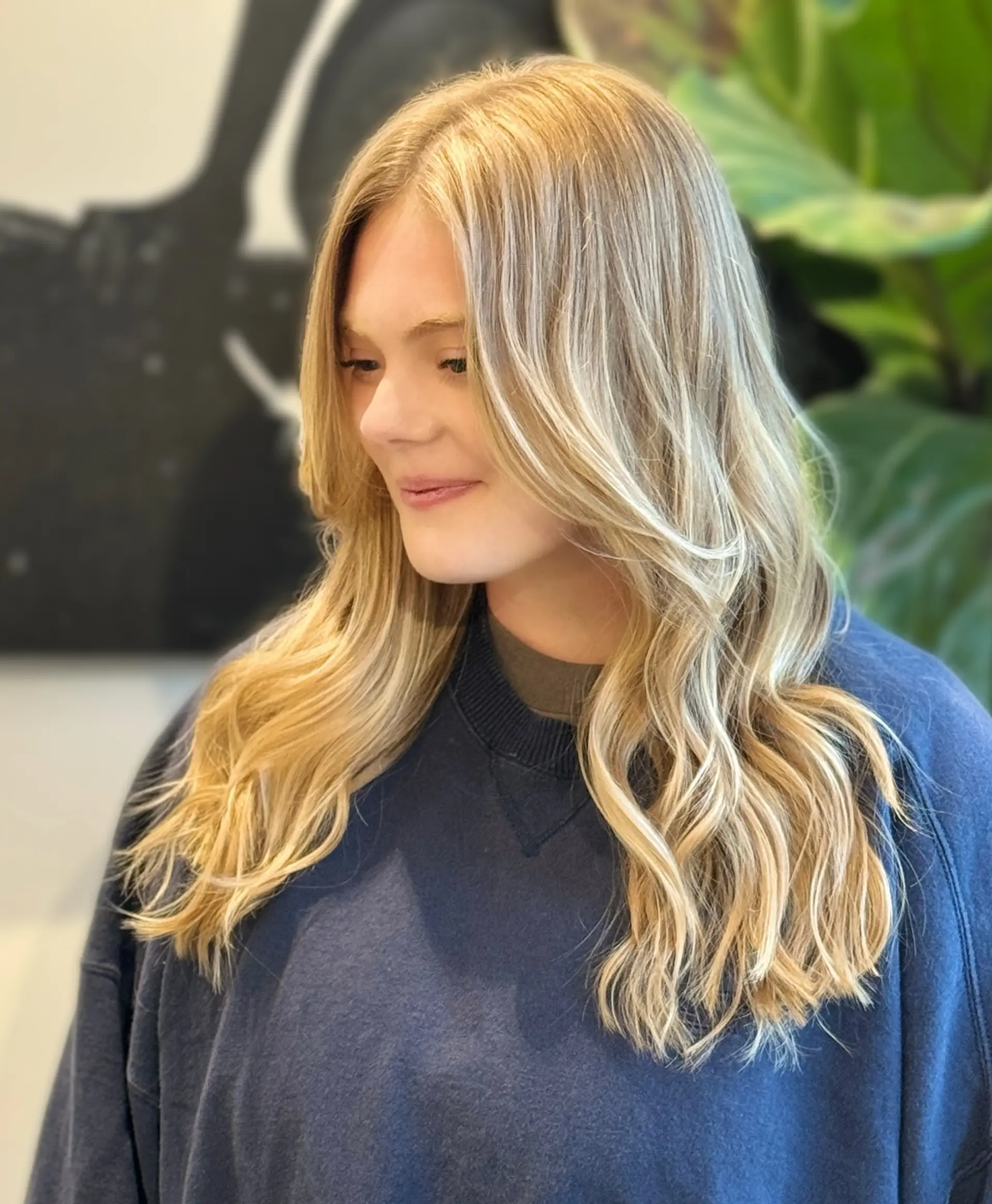 Long sun-kissed blonde balayage styled with soft, loose face-framing waves. 1