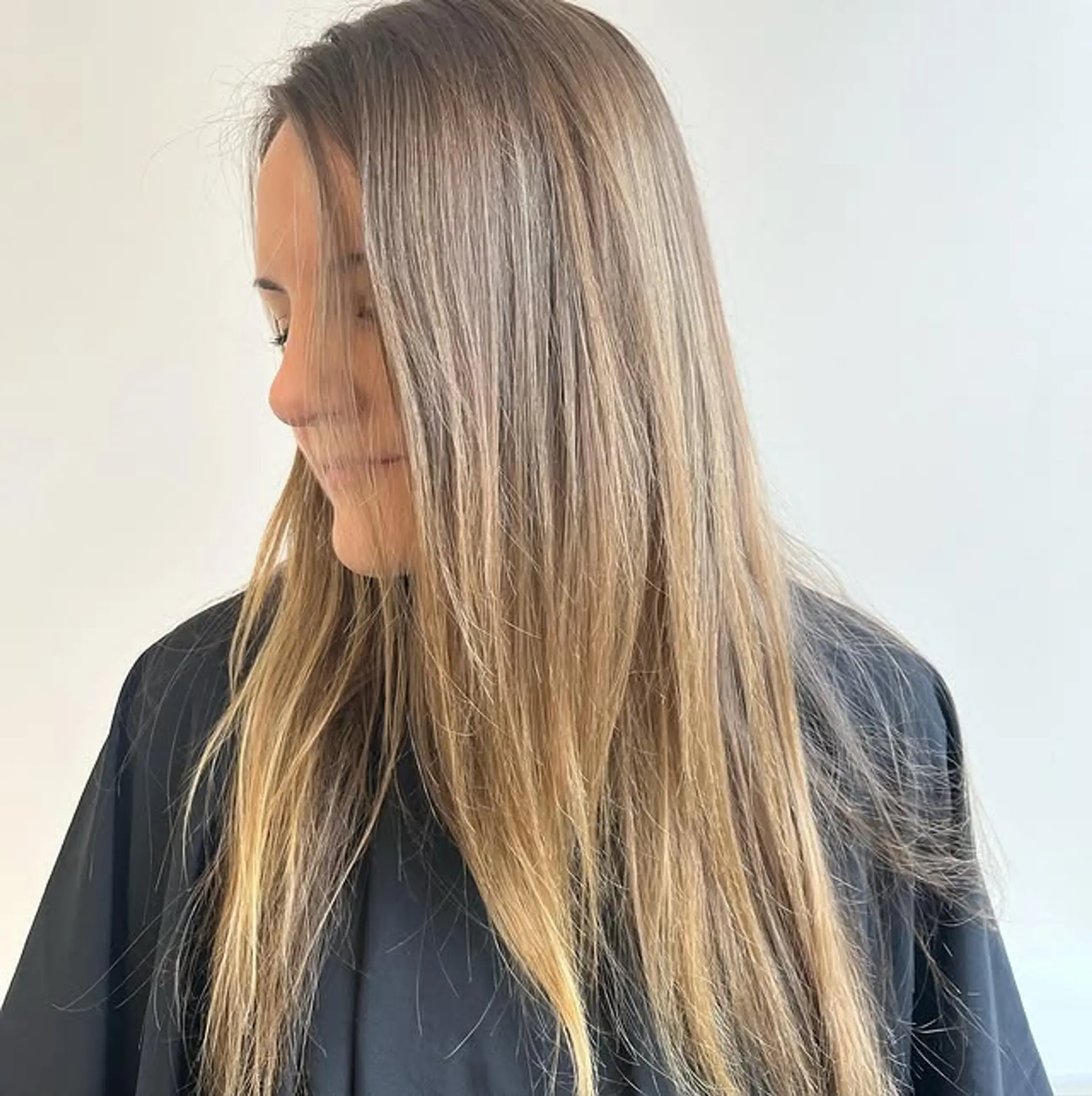 Long, straight hair with a dimensional brunette color that transitions into blonde ends, creating a balayage or ombre effect. 1