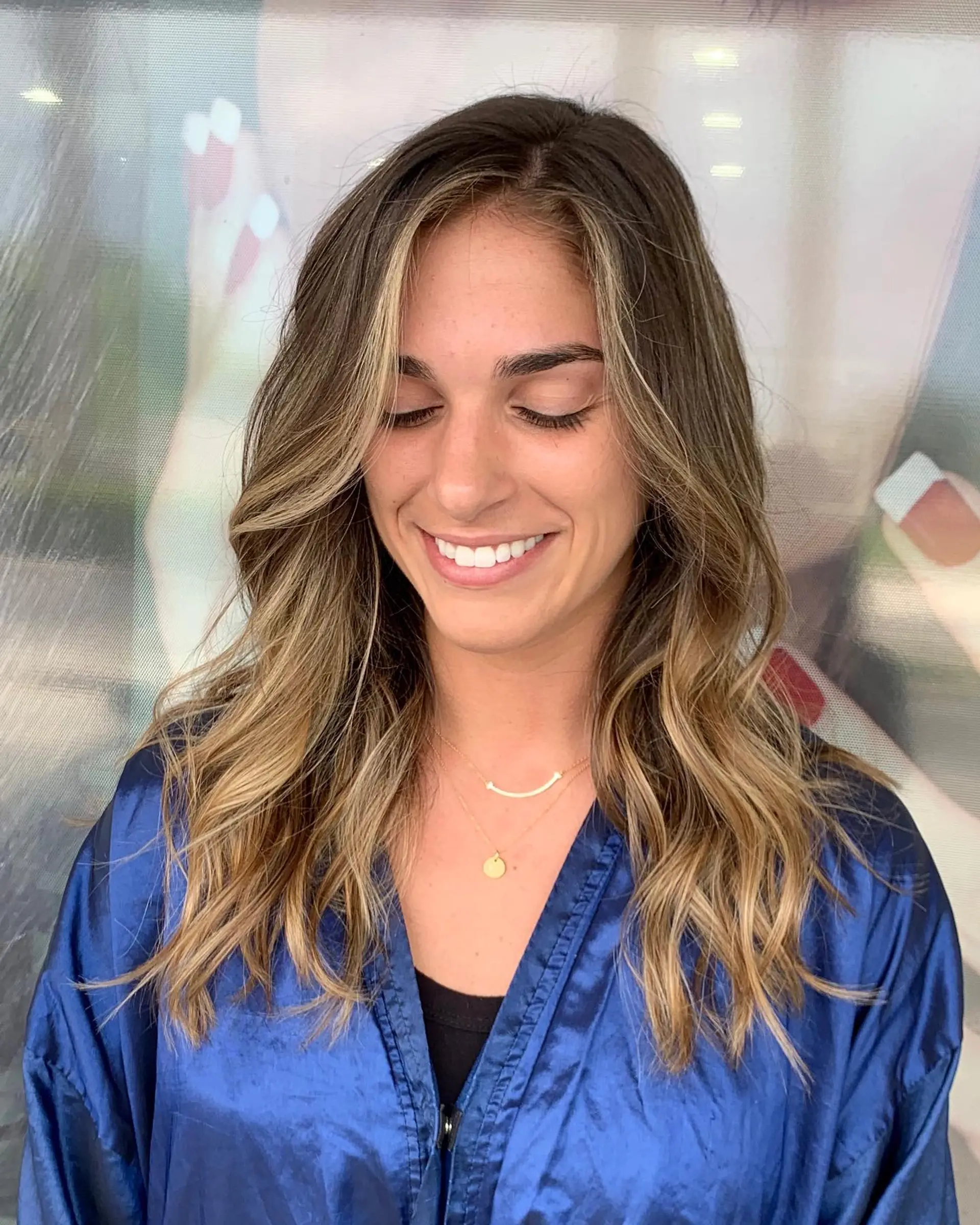 A medium-length wavy hairstyle with a brown to blonde balayage. 1