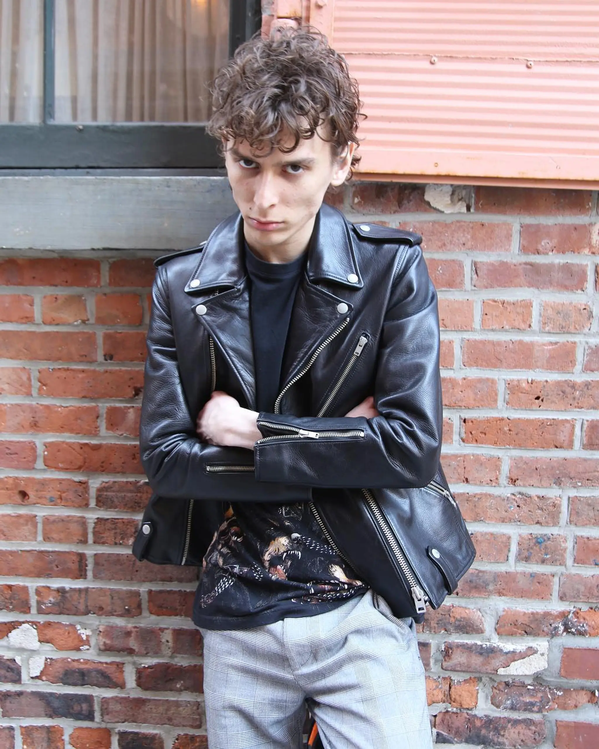 A short, tousled cut with layered, voluminous, and textured curly brown hair, featuring a fringe for an edgy, casual look.