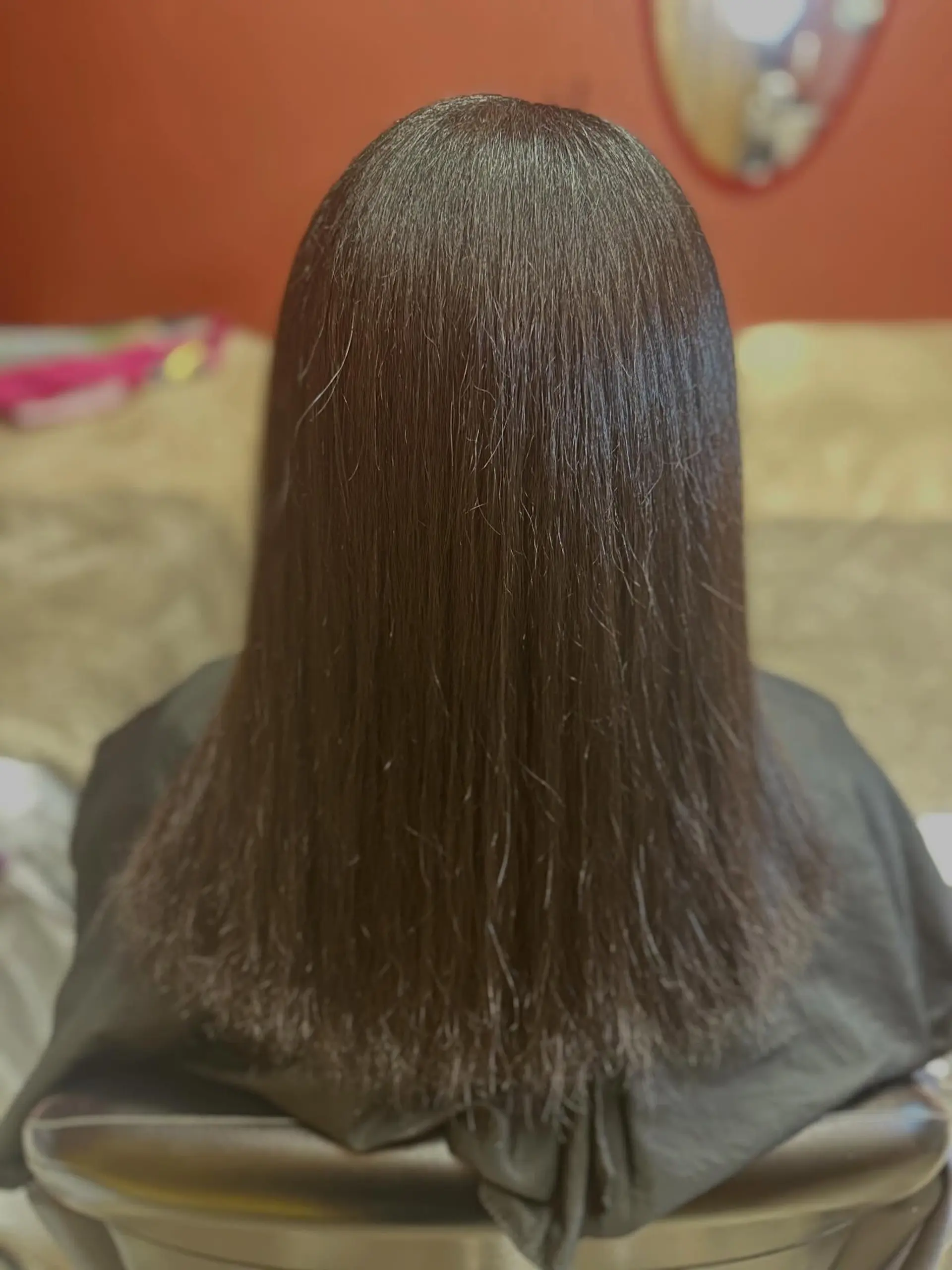Medium-length straight dark hair with a smooth, glossy finish. 1