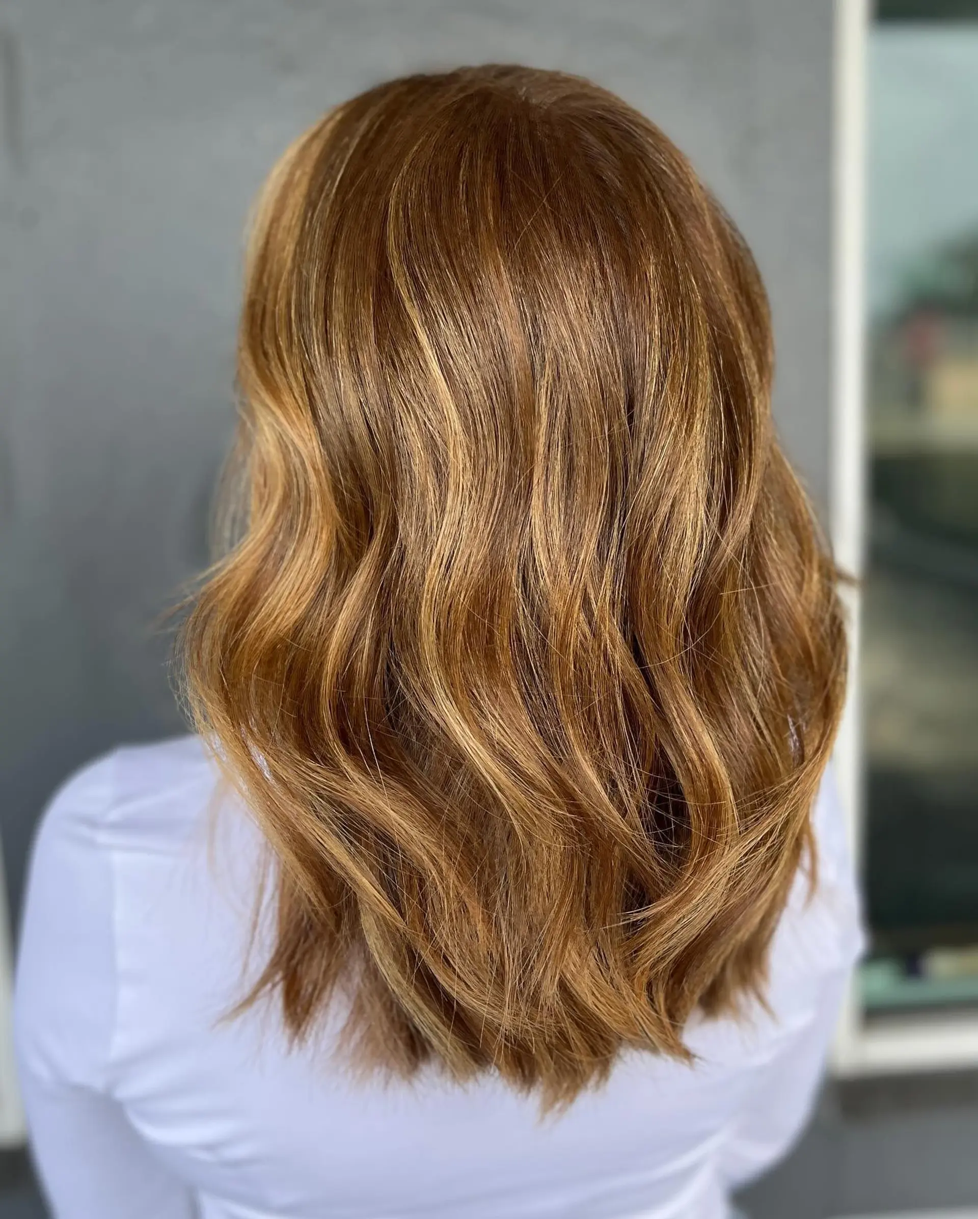 Medium-length wavy hairstyle with face-framing layers and golden blonde highlights. 2