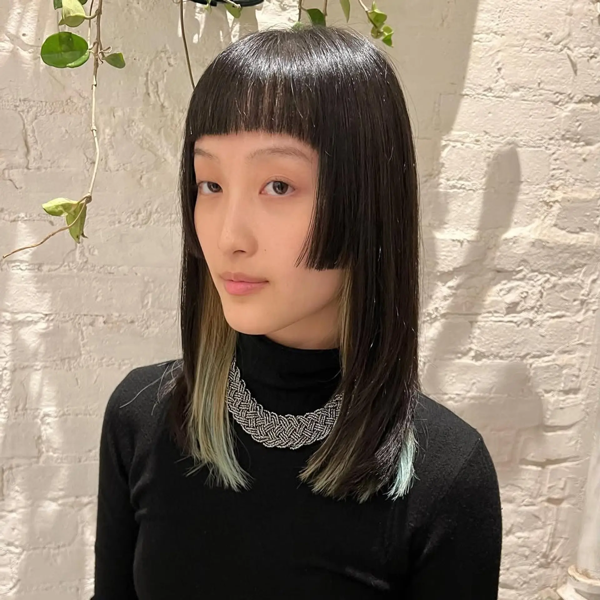 A box bob with blunt bangs and vibrant money piece highlights. 1