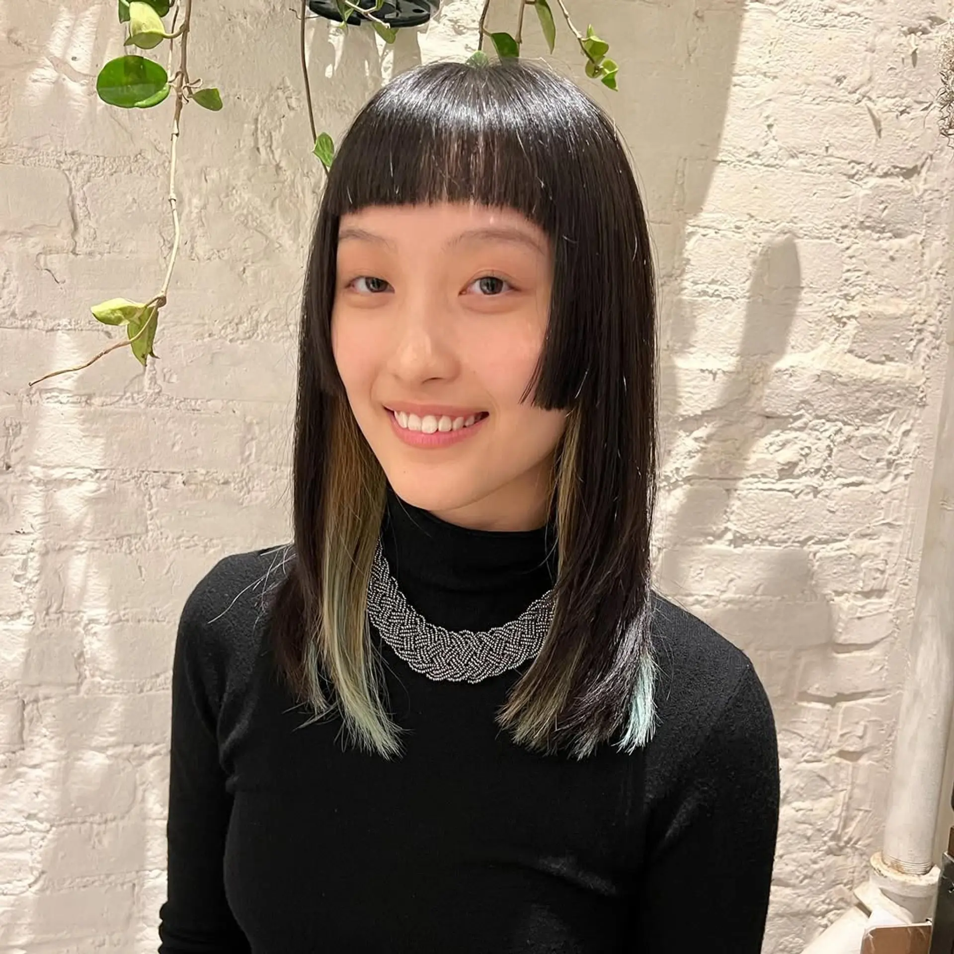 A box bob with blunt bangs and vibrant money piece highlights. 2