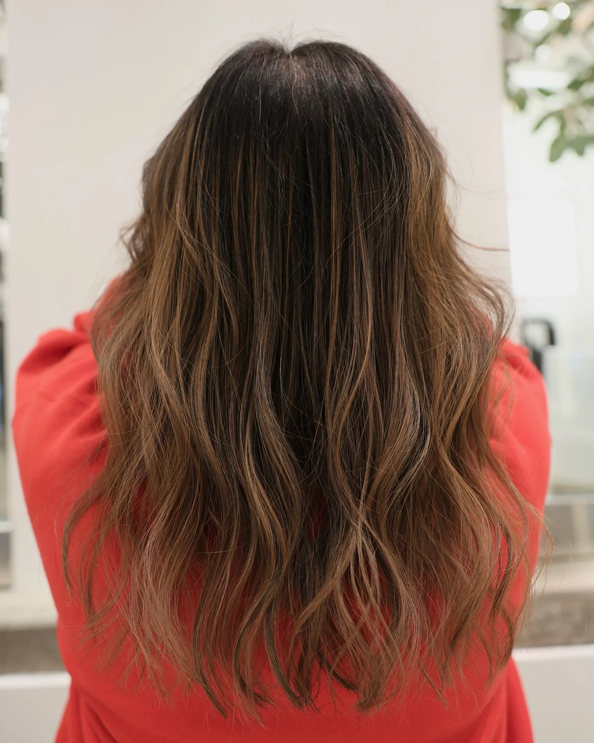 Long, wavy hair with a bronde balayage that transitions from dark roots to light blonde ends. 1