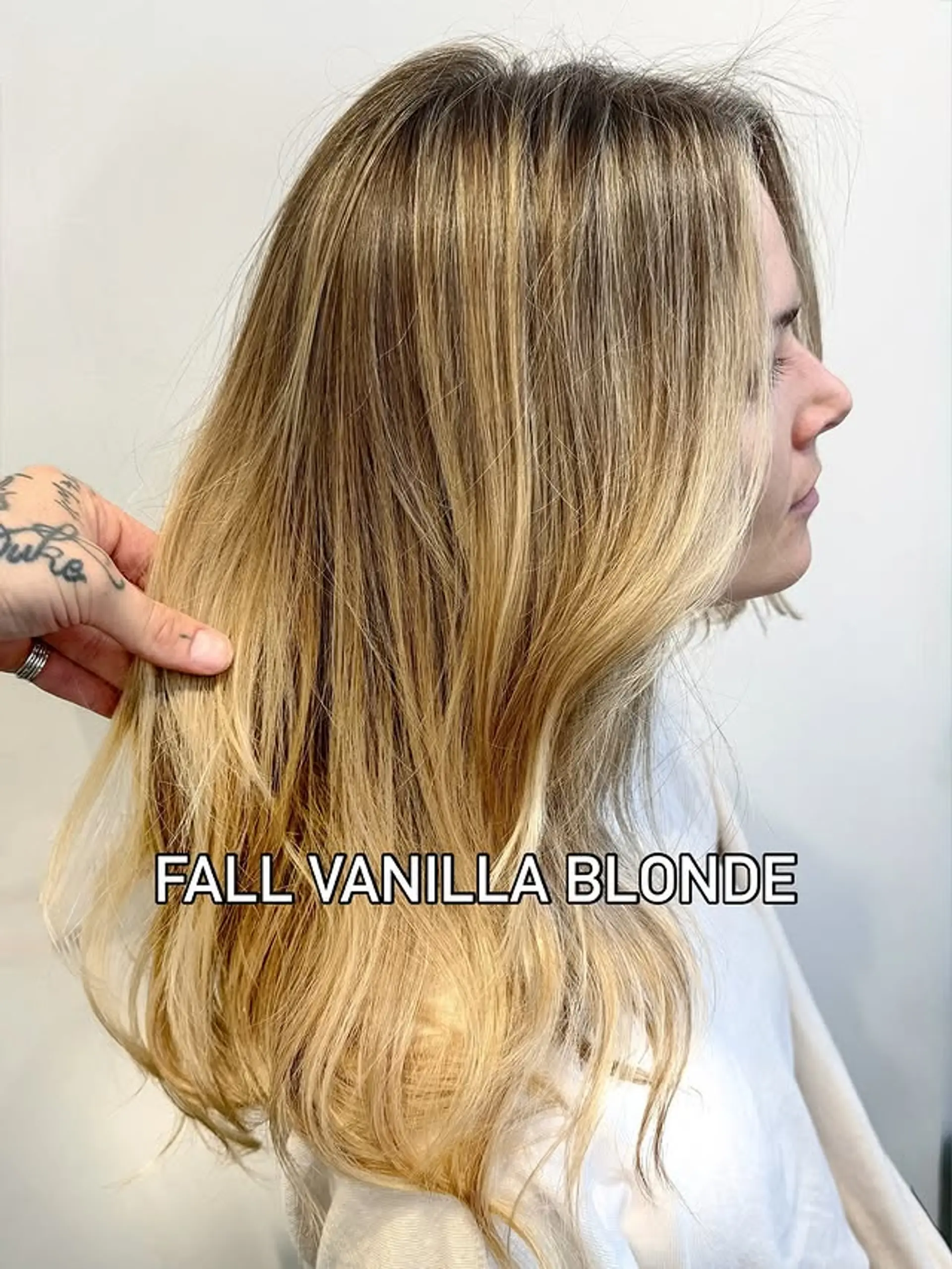 A medium-length hairstyle featuring a vanilla blonde balayage with subtle light brown roots. 1