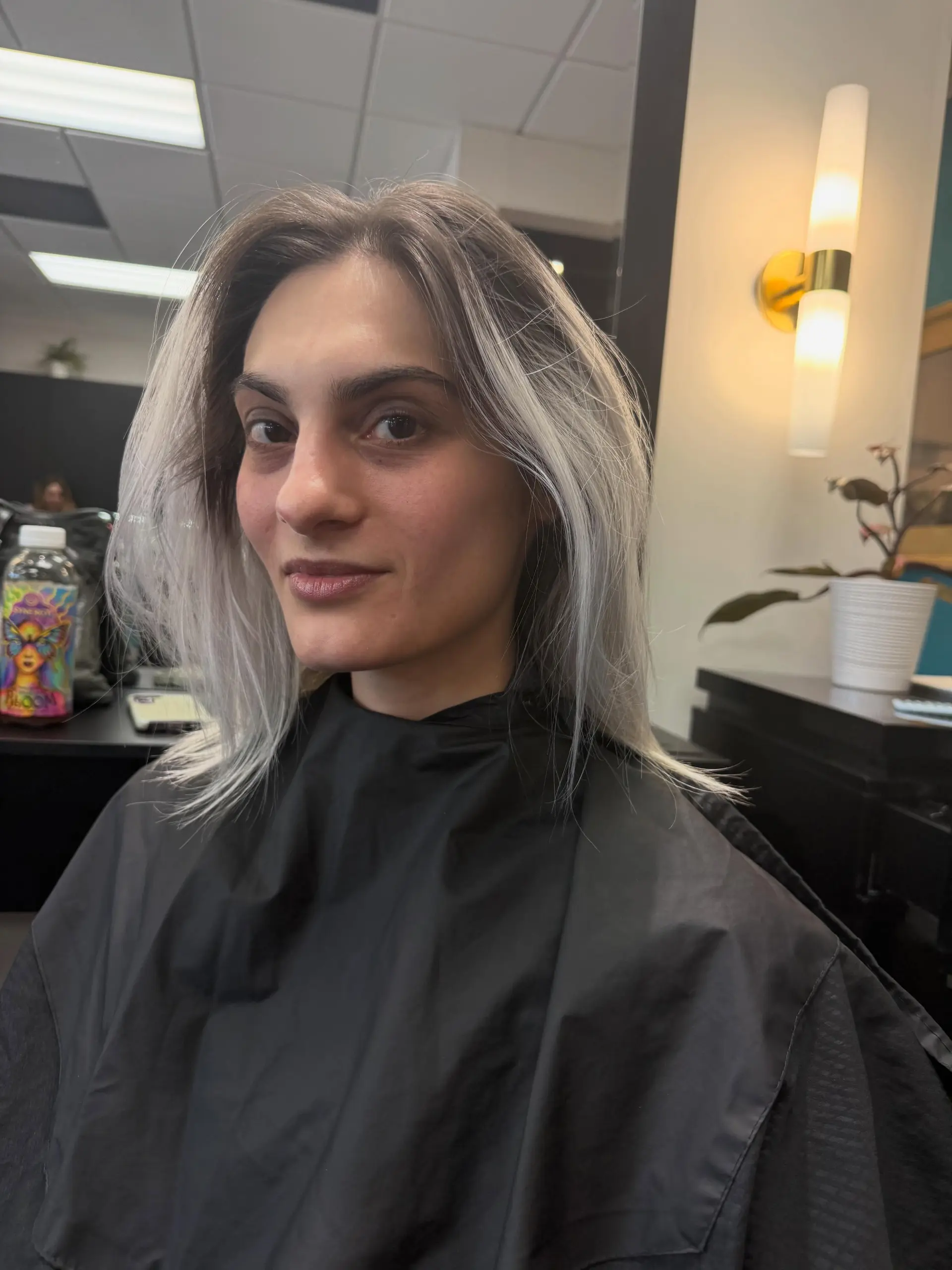 Medium-length textured lob with shattered face-framing layers in an icy blue-steel platinum blonde. 1