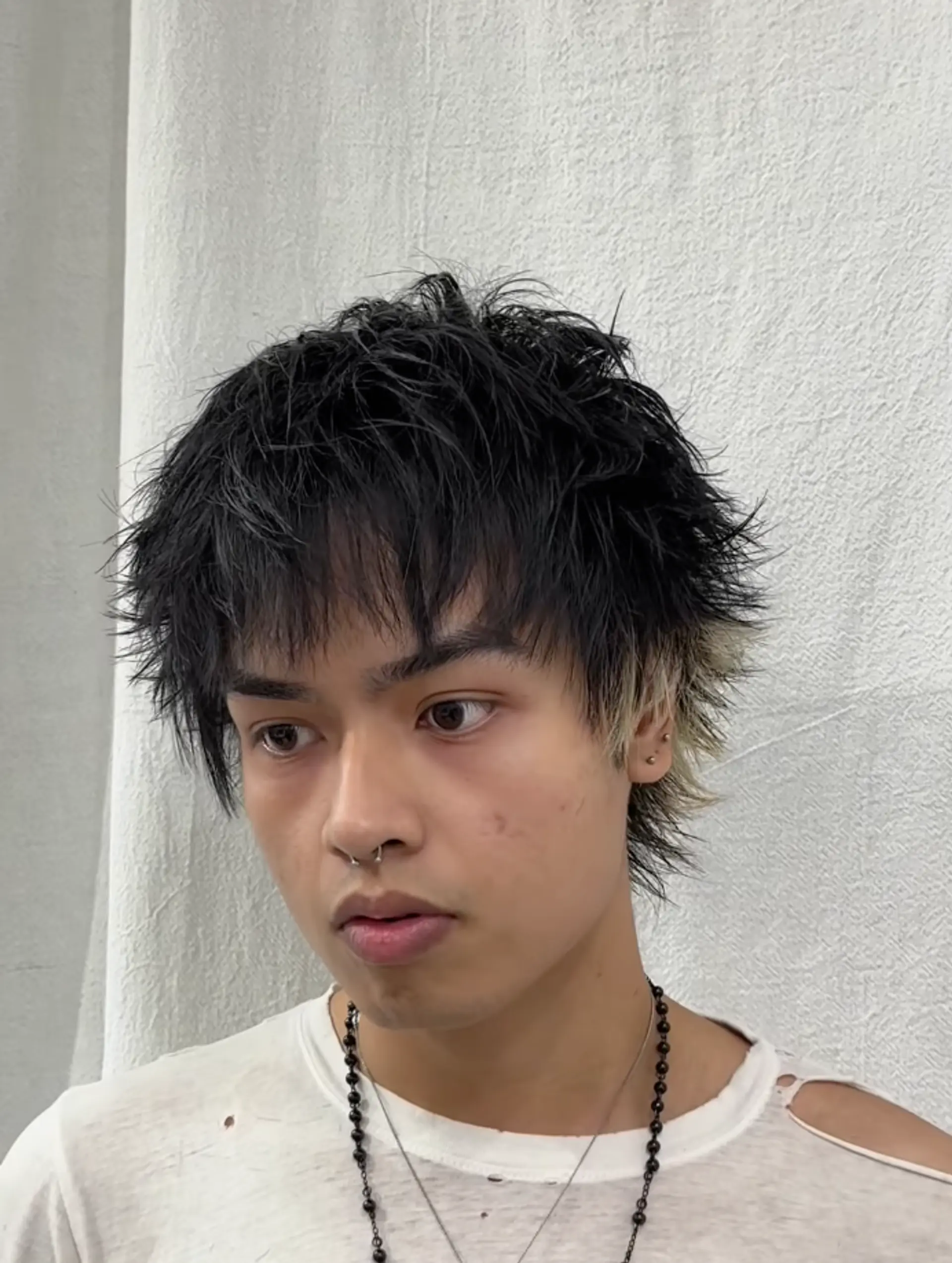 Medium-length wavy hair with choppy layers and blonde highlights, featuring a textured wave and fringe bangs. 1