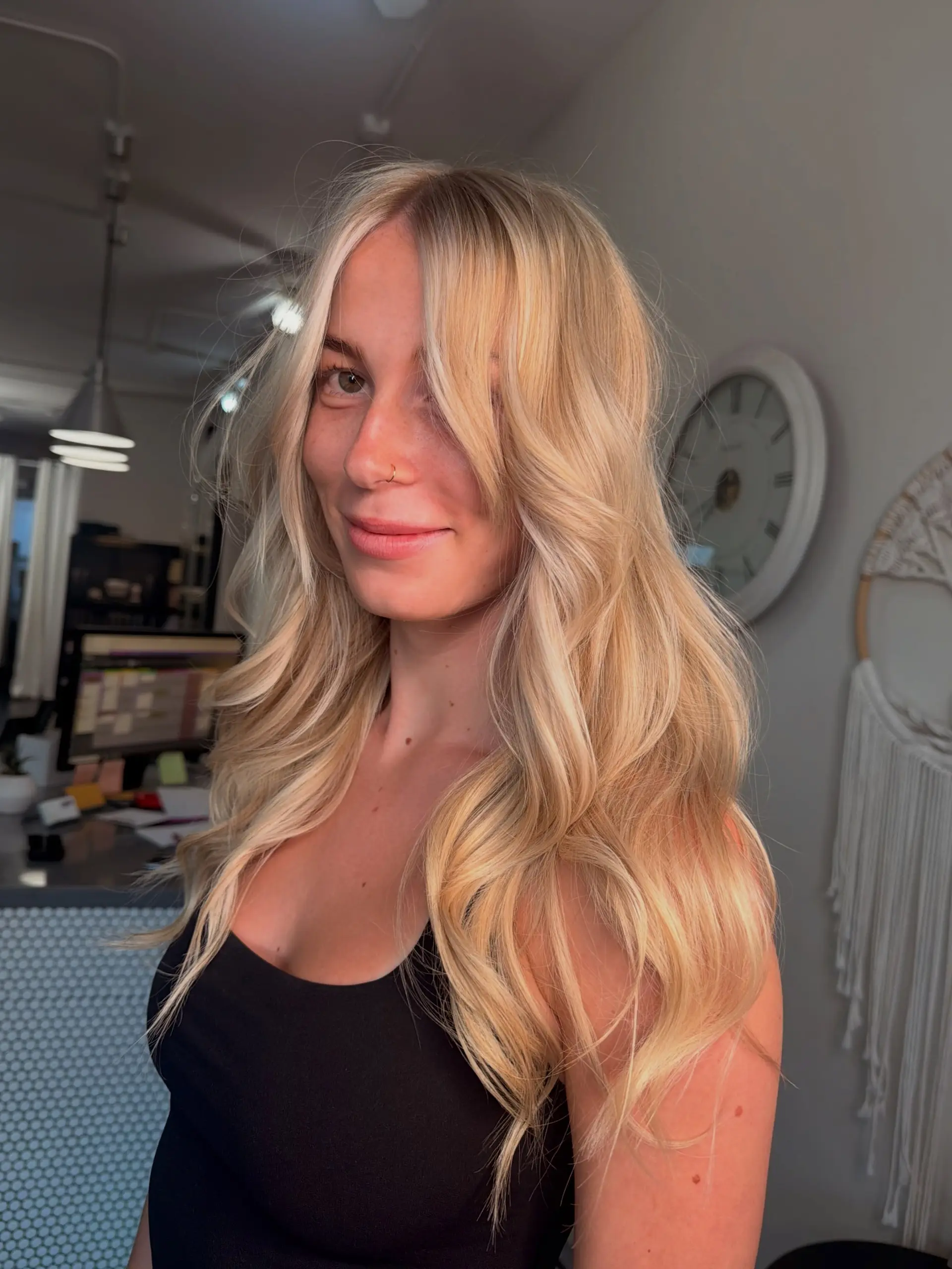 Long, luminous blonde hair styled in soft, bouncy salon waves with a voluminous blowout finish and face-framing layers. 1