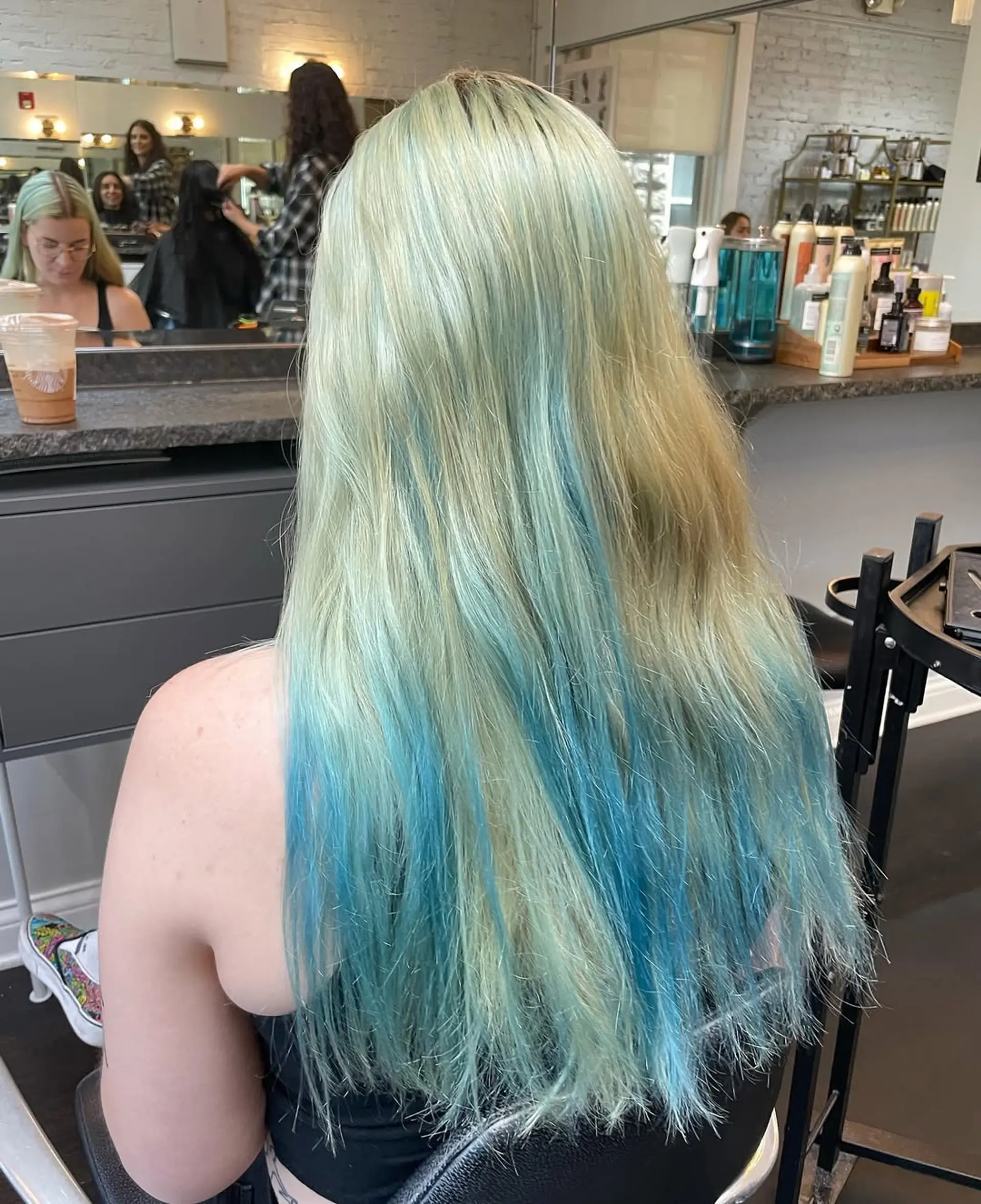 A very long, wavy hairstyle characterized by soft, flowing waves cascading down the back. The look is achieved with a multidimensional fantasy color application. 2