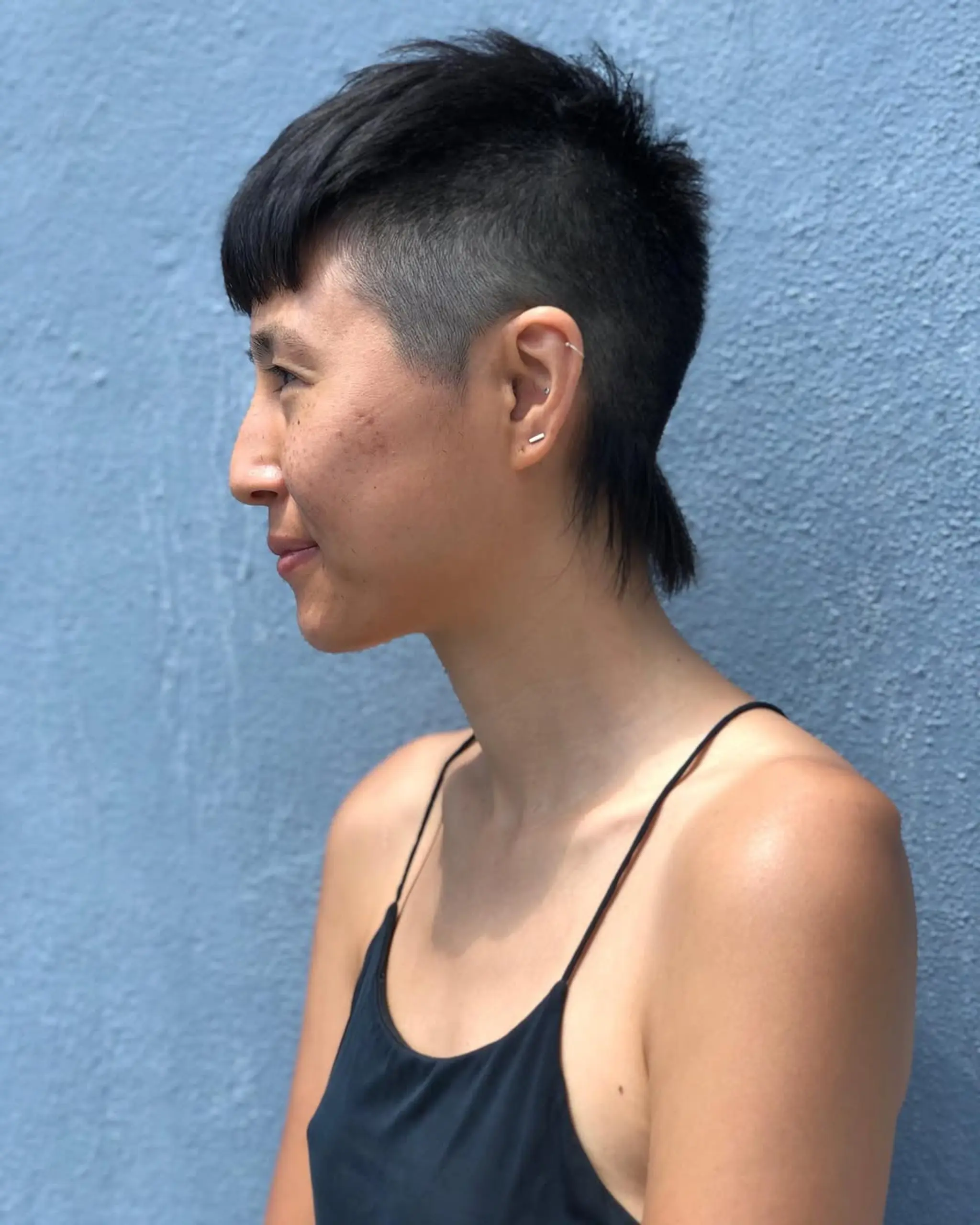 A modern mullet with an undercut, featuring a textured top and a long nape with a side fade. 1