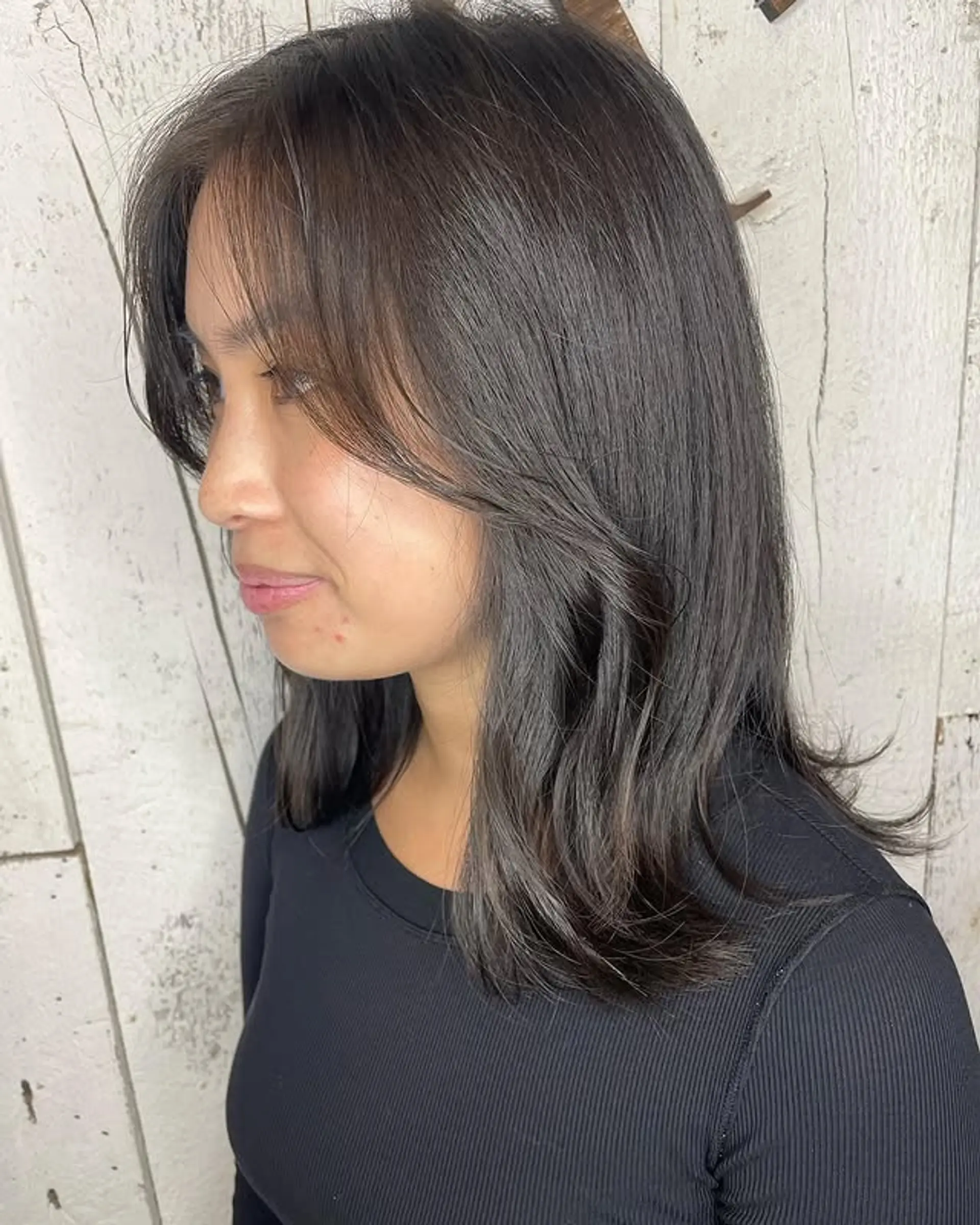 A medium-length layered hairstyle with face-framing layers and curtain bangs. 1