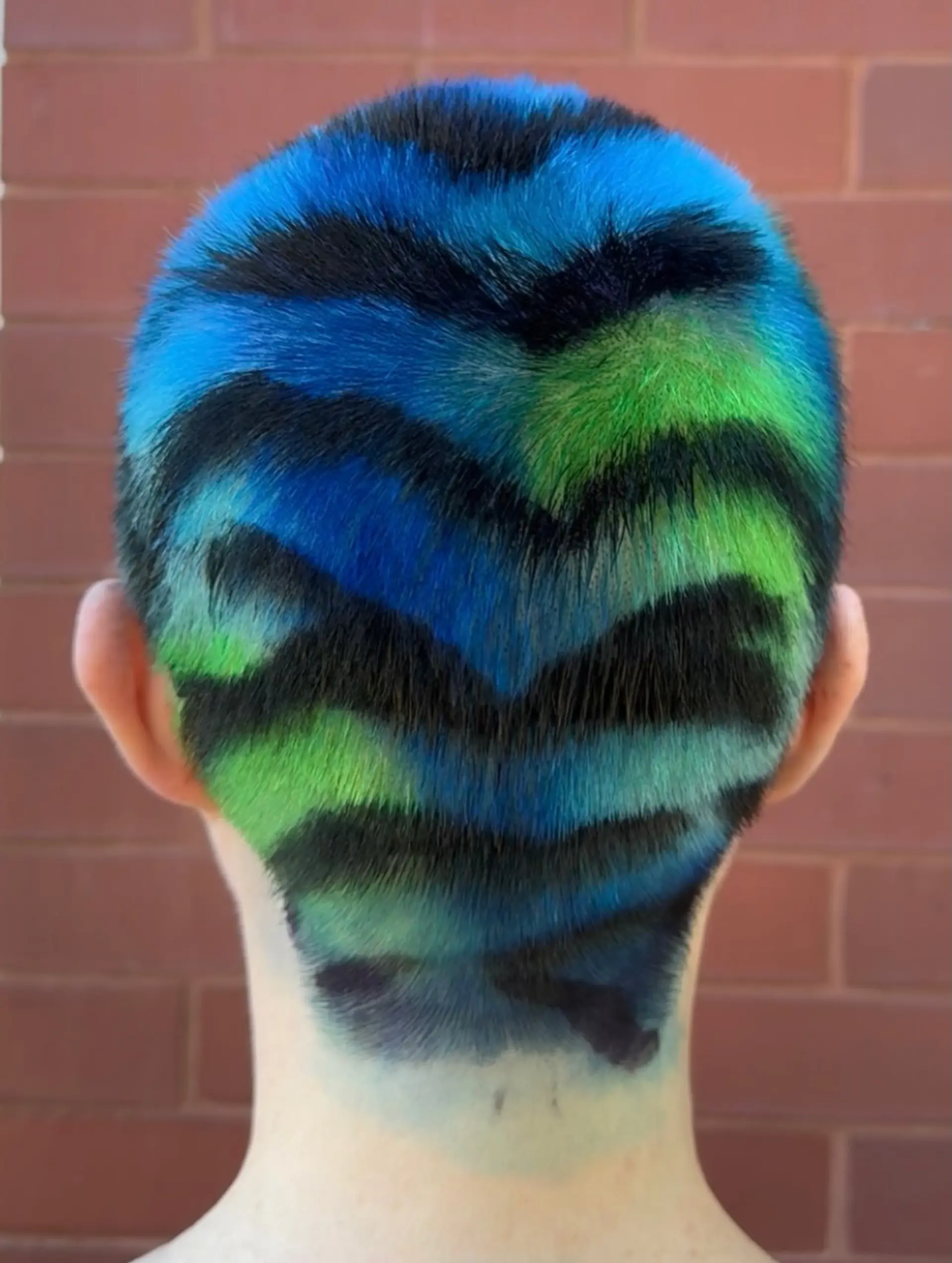 An artistic buzz cut dyed with vibrant blue and green tones and detailed with hand-painted black tiger stripes. 1