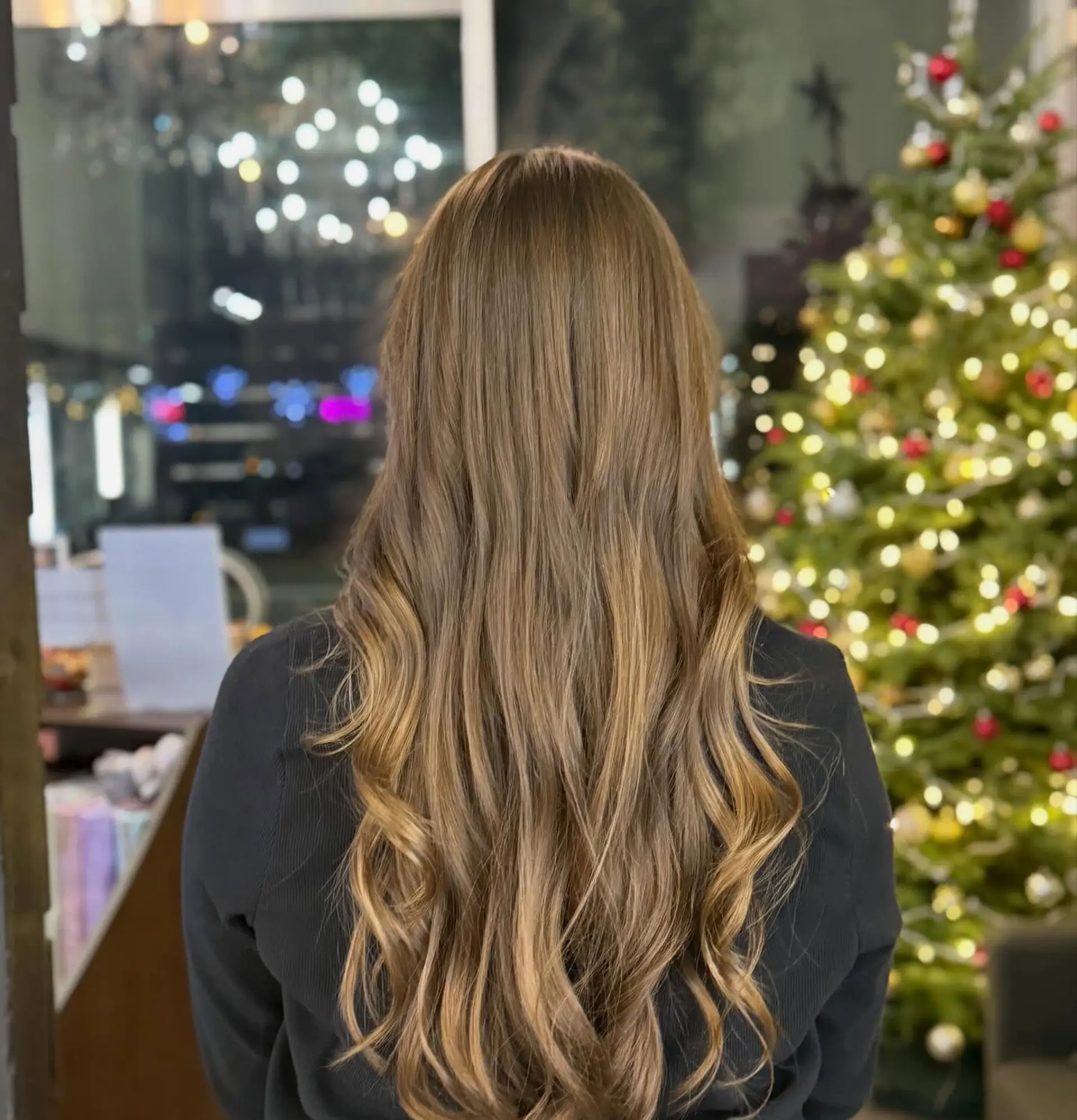 Long layered light brown hair with subtle caramel highlights styled into soft, elegant curls. 1