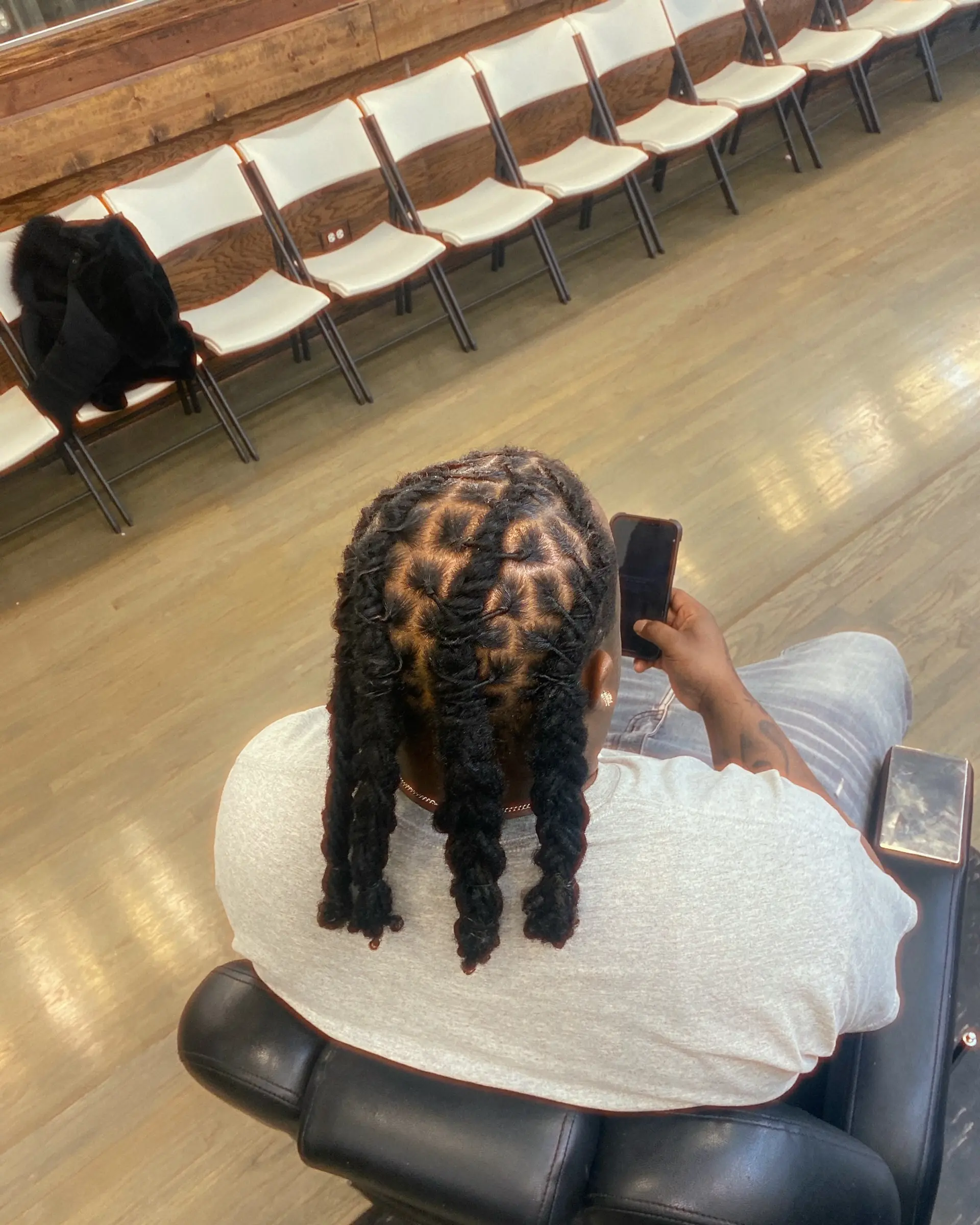 Locs with braided extensions and a stylish geometric part design. 1