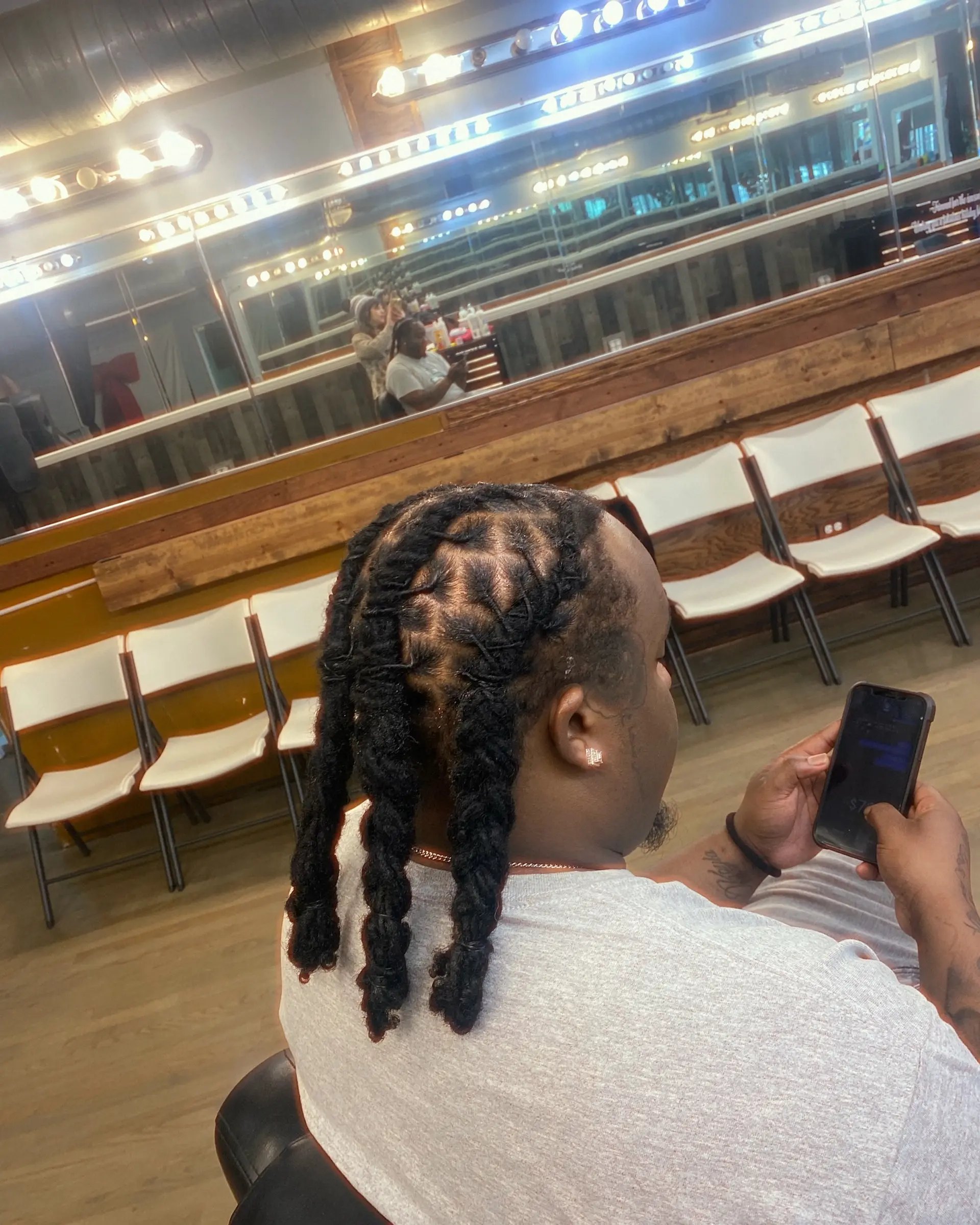 Locs with braided extensions and a stylish geometric part design. 2