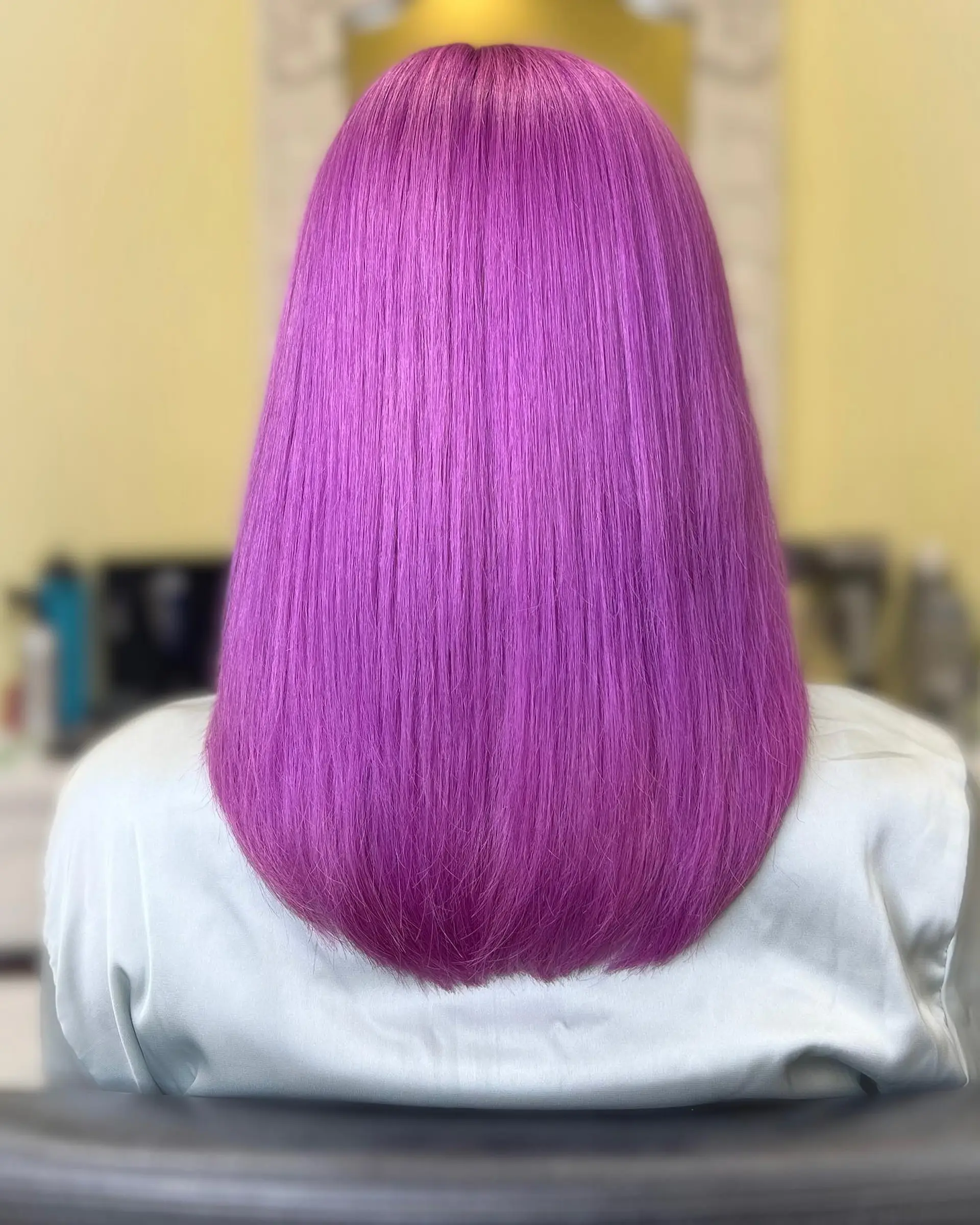 A medium-length long bob, also known as a lob, with a sleek and straight finish. The style features a center part and falls just below the shoulders. 2