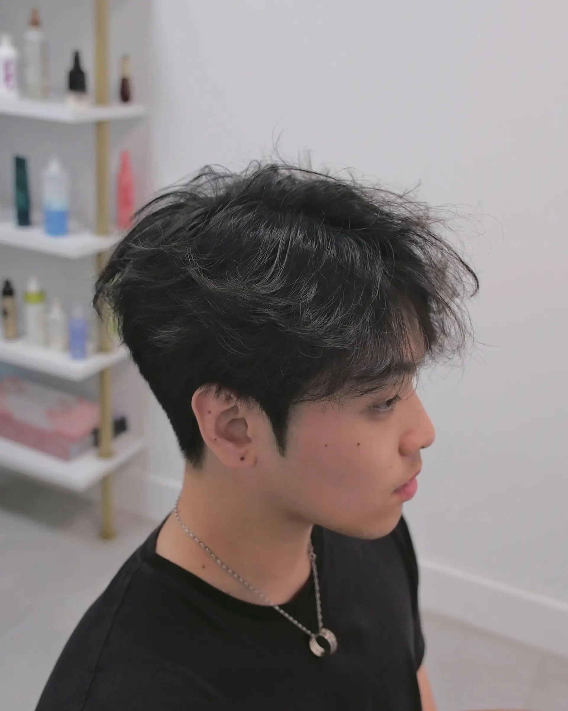 A short haircut featuring a textured top with tapered sides. 2