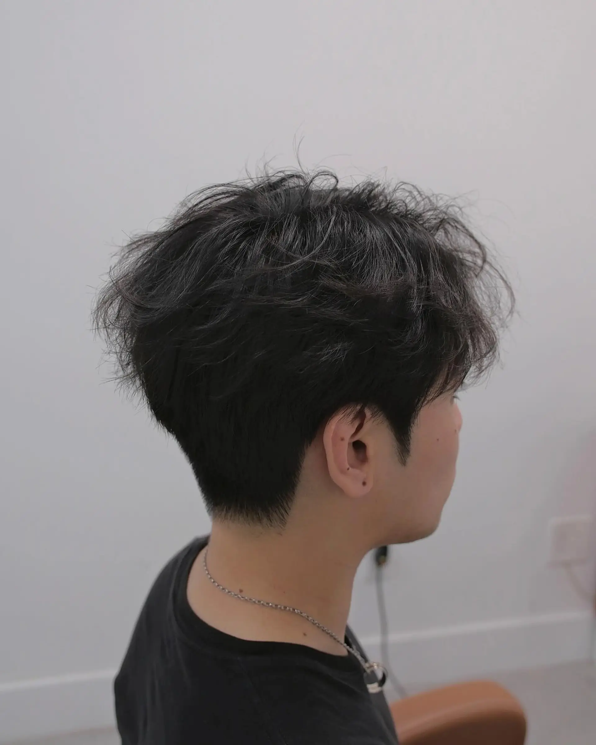 A short haircut featuring a textured top with tapered sides. 3