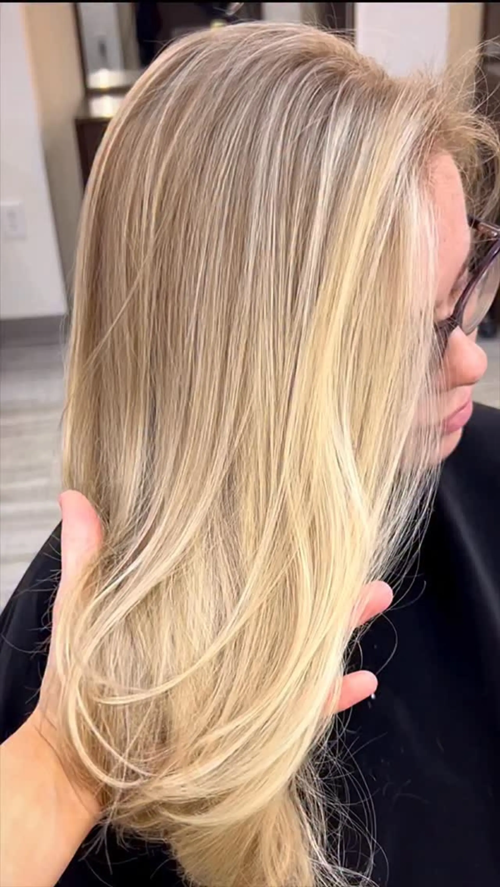 Straight, silky blonde hair featuring seamlessly blended warm highlights and a brighter face-framing hairline. 1