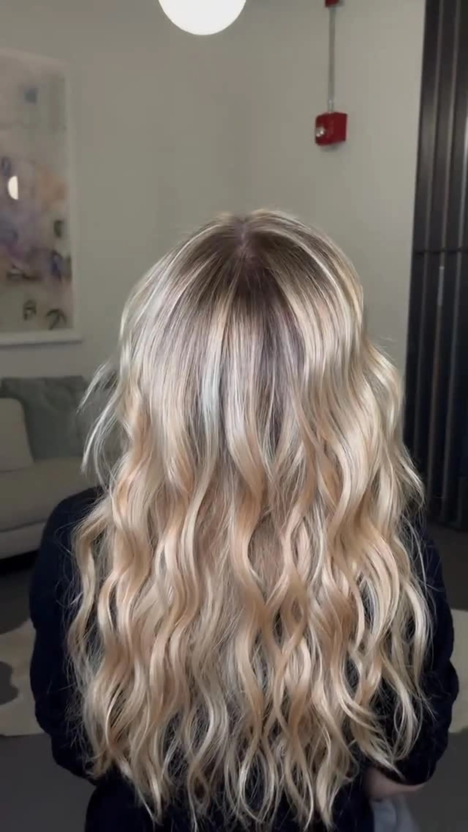 Long, cool-toned blonde hair featuring dimensional highlights and soft, polished waves. 1