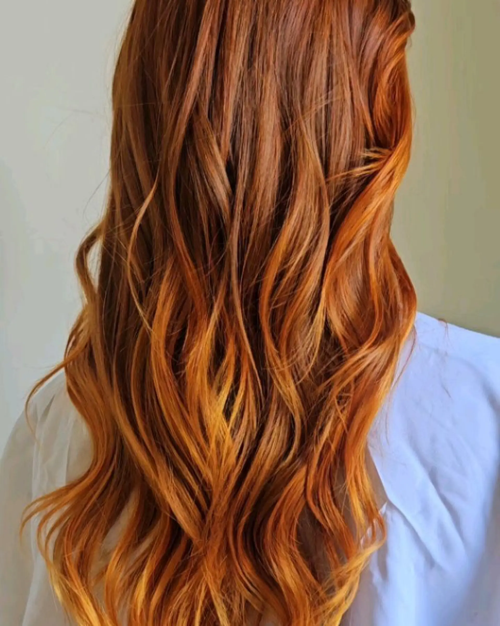Long, dimensional copper-orange hair styled in flowing, soft waves that catch the light. 1