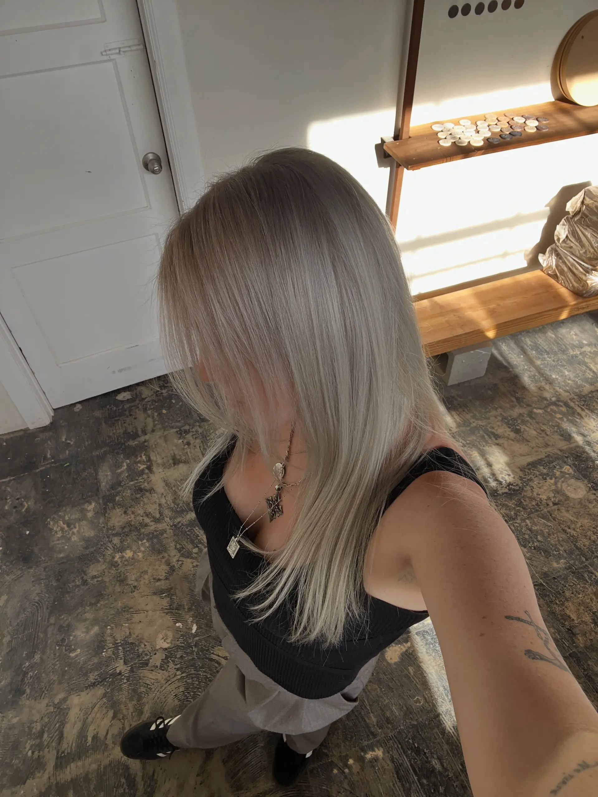 Long, straight hair colored in a seamless cool platinum ash blonde and styled smooth. 1